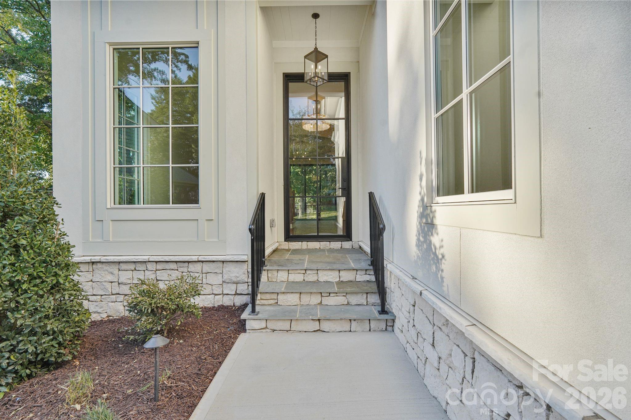 Welcoming front porch featuring timeless flagstone steps, adding natural texture and an elevated finish to the home’s grand entrance. - 21216 Rio Oro Drive, Cornelius