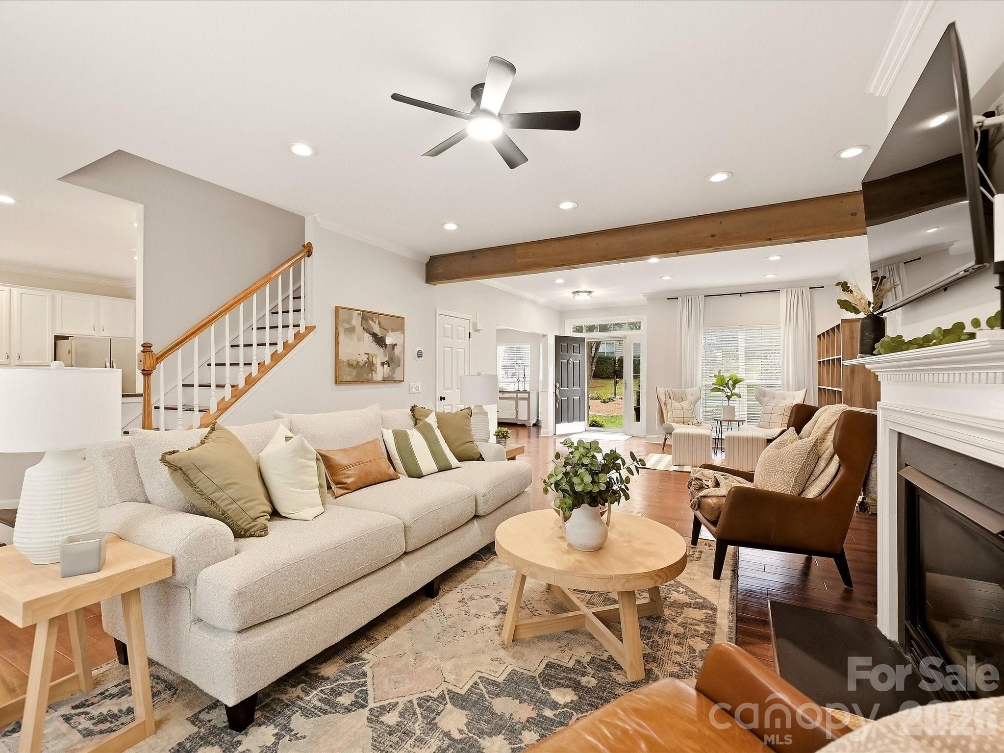 The inviting Great Room features a cozy fireplace, rich wood floors, abundant natural light, and plenty of space for comfortable everyday living. - 16006 Lavenham Road, Huntersville