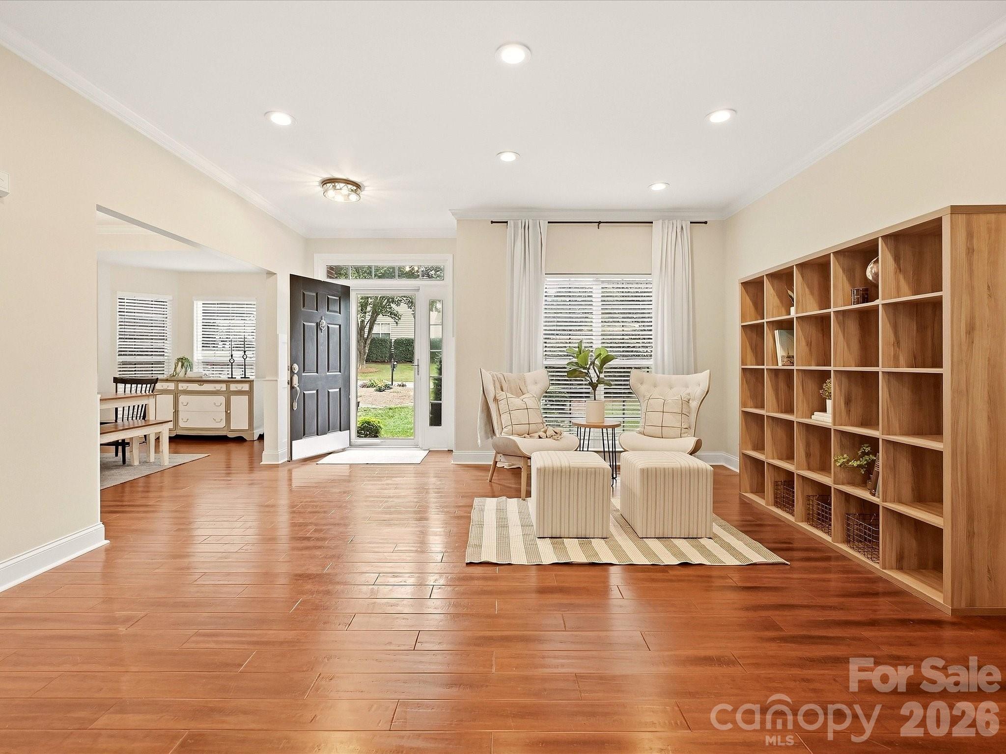 The spacious living room features rich wood floors, abundant natural light, and a cozy sitting area that creates a warm and welcoming atmosphere. - 16006 Lavenham Road, Huntersville