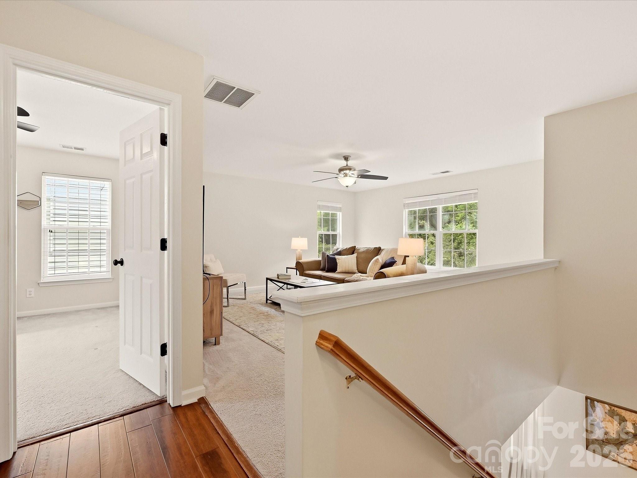 The bright upper-level landing opens to a spacious loft and additional bedroom, creating a flexible transition between the home’s upstairs living spaces. - 16006 Lavenham Road, Huntersville