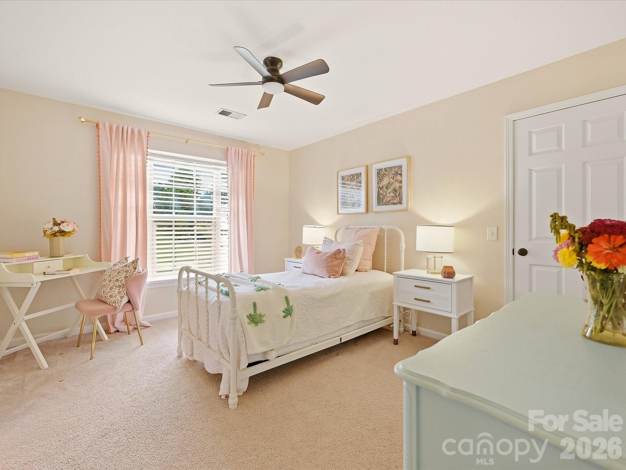 Bedroom 4 is a bright and inviting space with soft neutral finishes, abundant natural light, a ceiling fan, and room for a dedicated desk or study area. - 16006 Lavenham Road, Huntersville