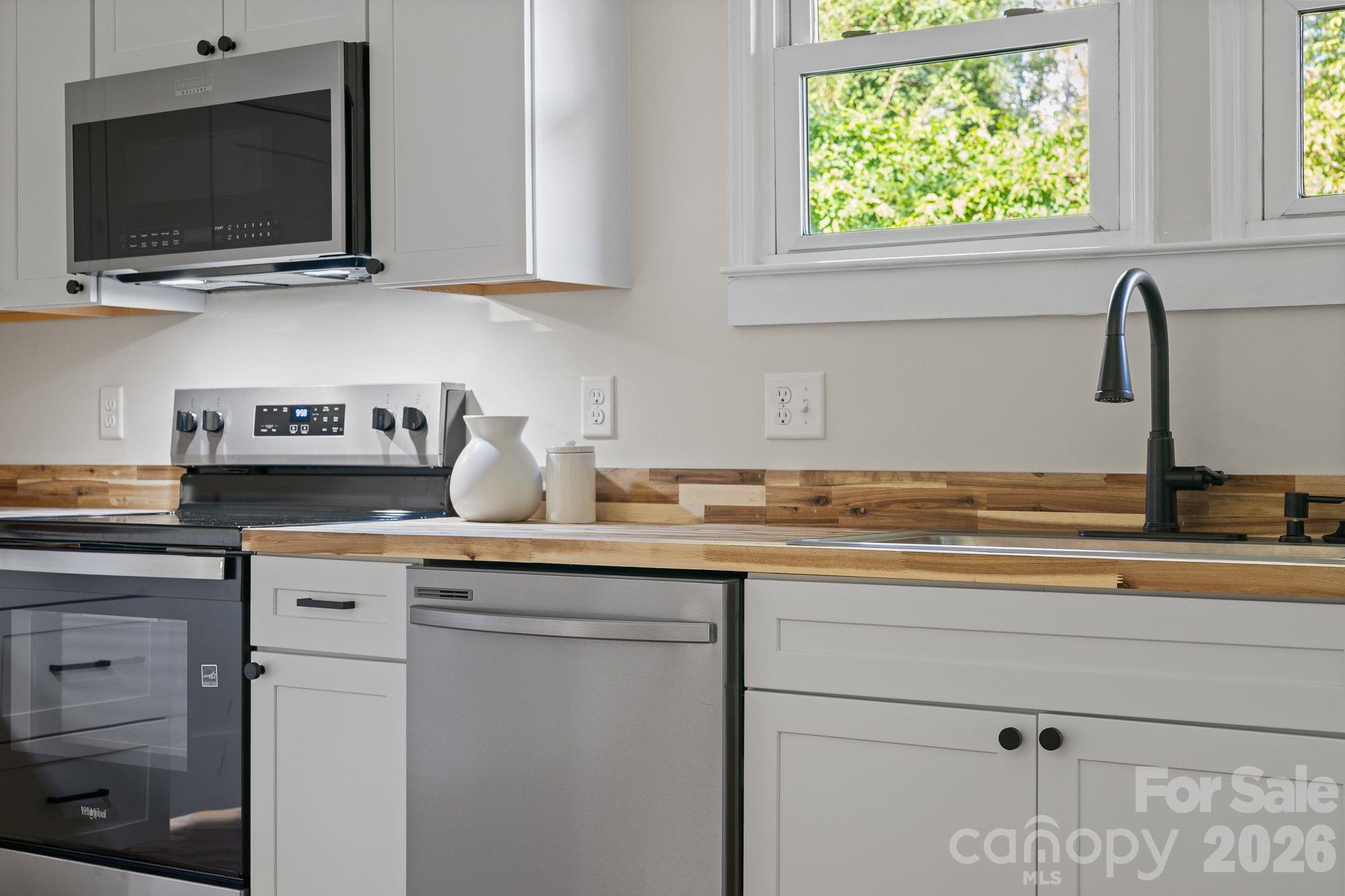 Kitchen: Renovated kitchen featuring butcher block countertops and new stainless steel appliances. - 156 State Street, Asheville