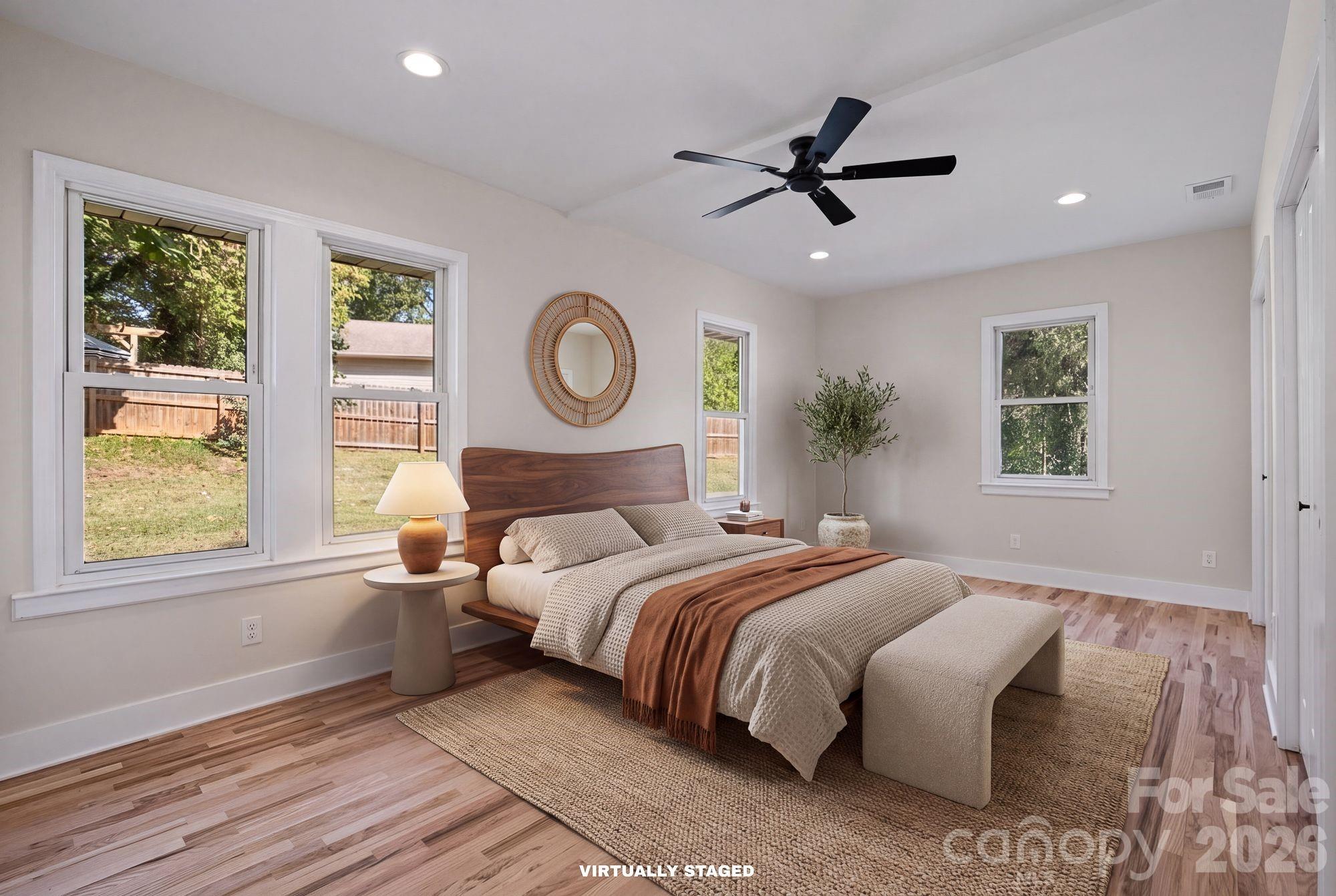 Virtually Staged Primary Bedroom: Spacious main-level primary suite with private en-suite bath. - 156 State Street, Asheville