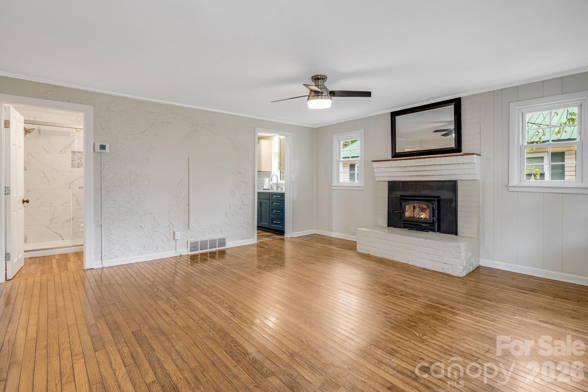 Walk into the living room. Wood burning fireplace. Guest bath to the left and kitchen to the right. - 1015 Mountain View Street, Hendersonville