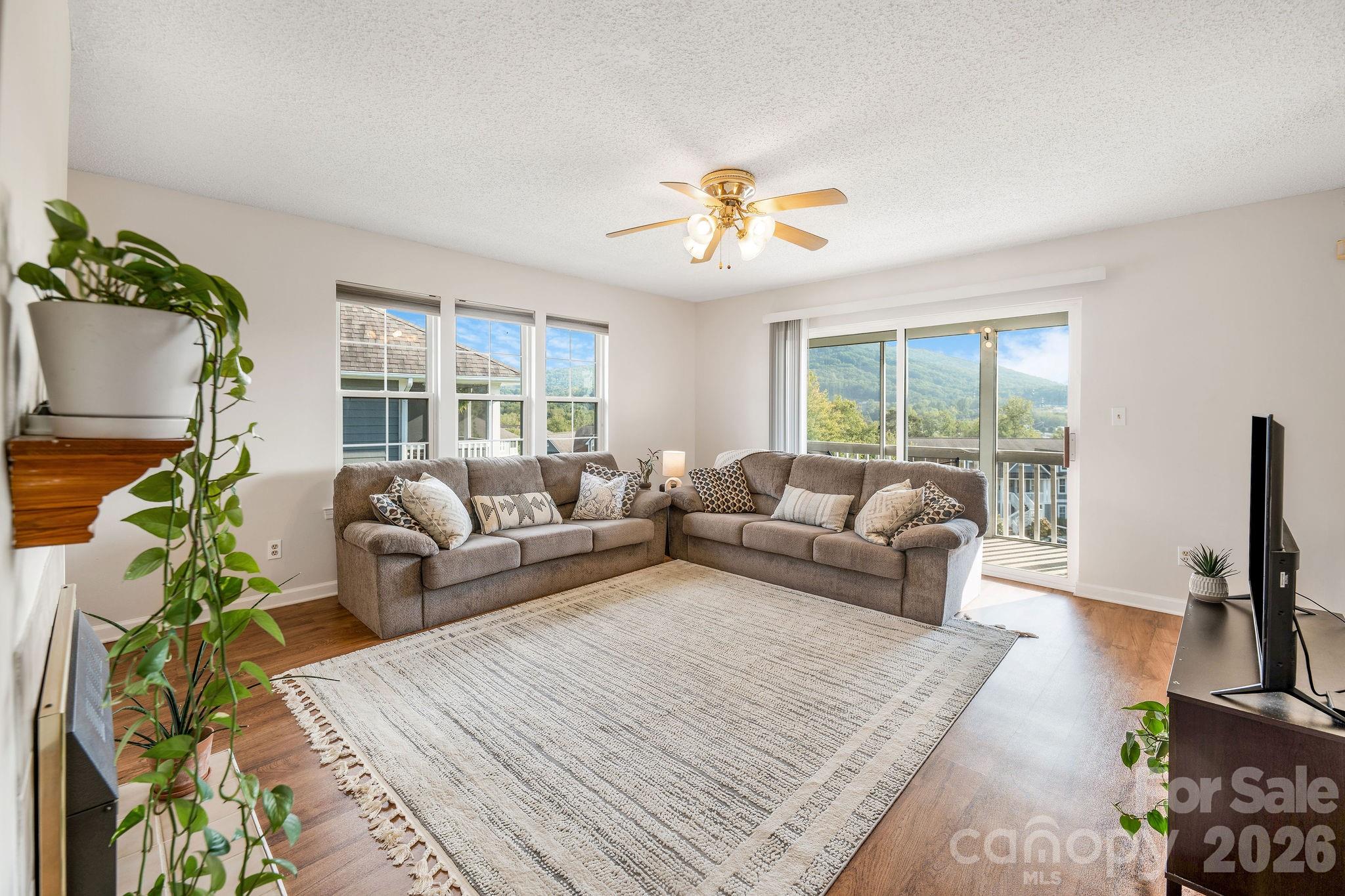 Large living room with views out the sliding glass doors. - 4702 Breakers Lane, Asheville