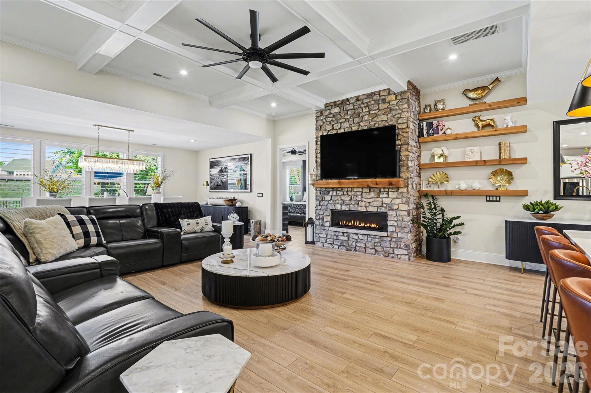 Floor-to-ceiling stone gas fireplace, coffered ceiling, and floating shelves. - 8027 Longwaters Court, York
