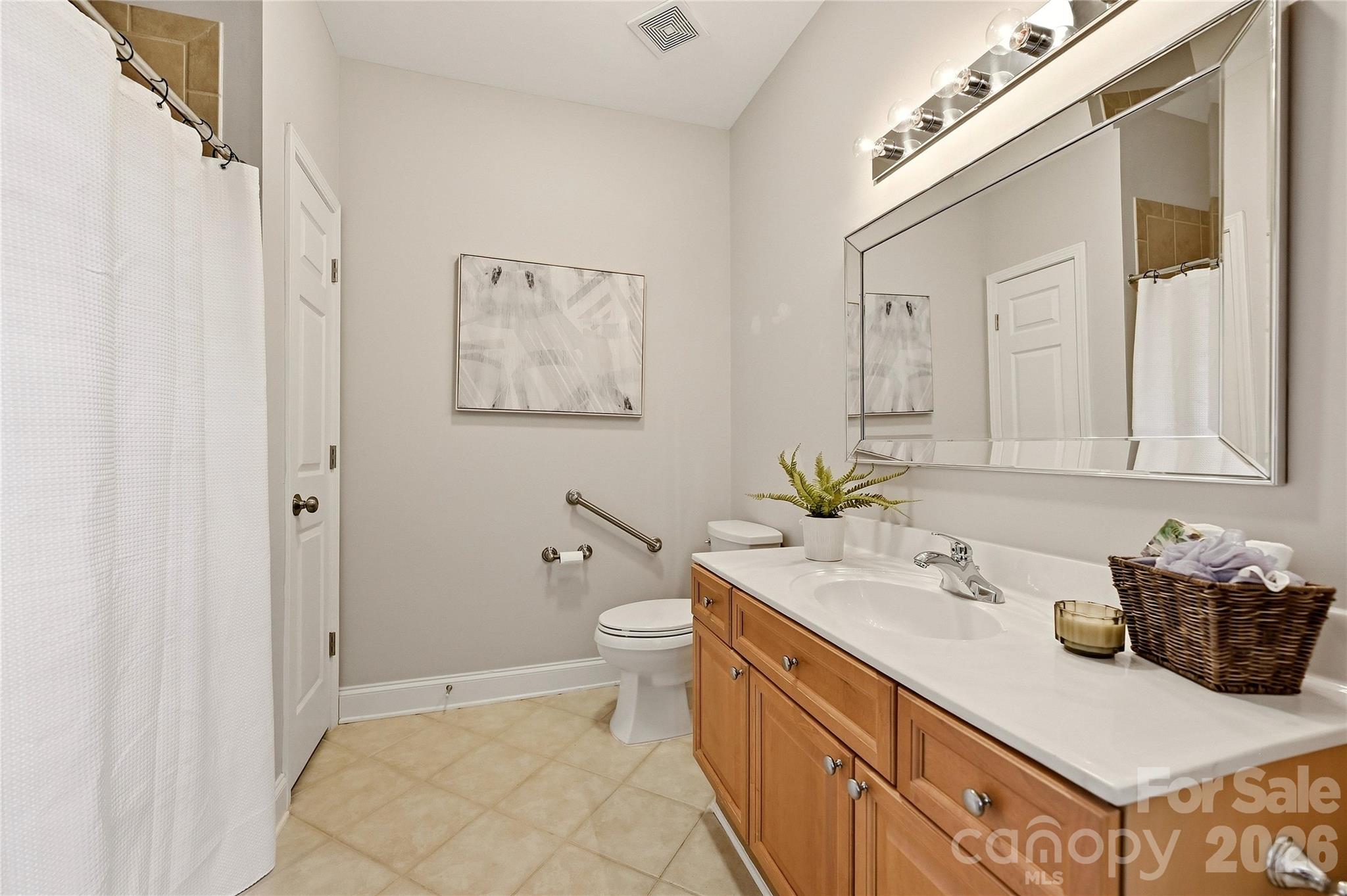 Full guest bathroom features a spacious vanity, tile flooring, and tub-shower combination. - 9009 Rosalyn Glen Road, Cornelius