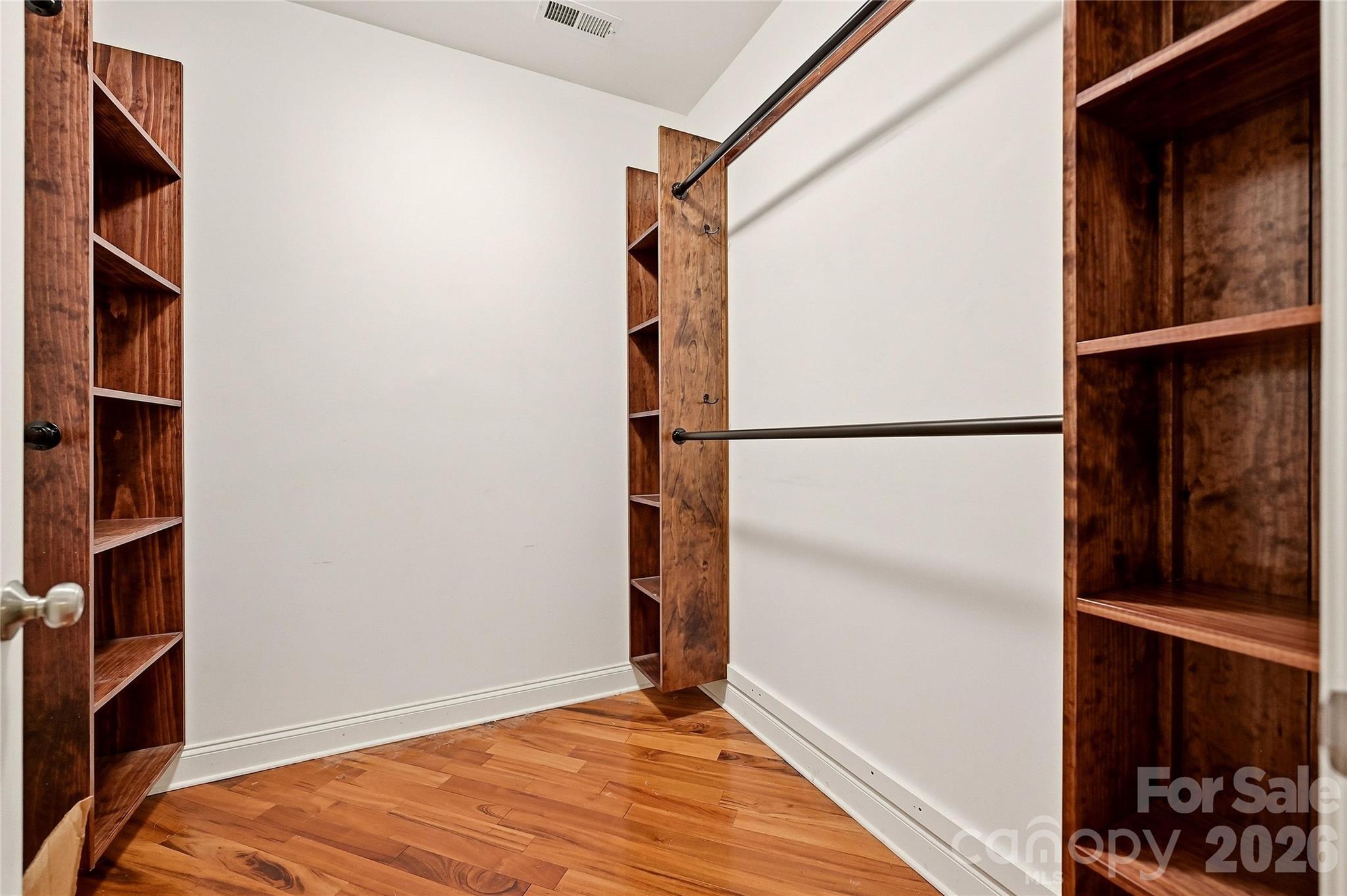 Custom primary walk-in closet system provides extensive built-in shelving and organized storage space. - 9009 Rosalyn Glen Road, Cornelius