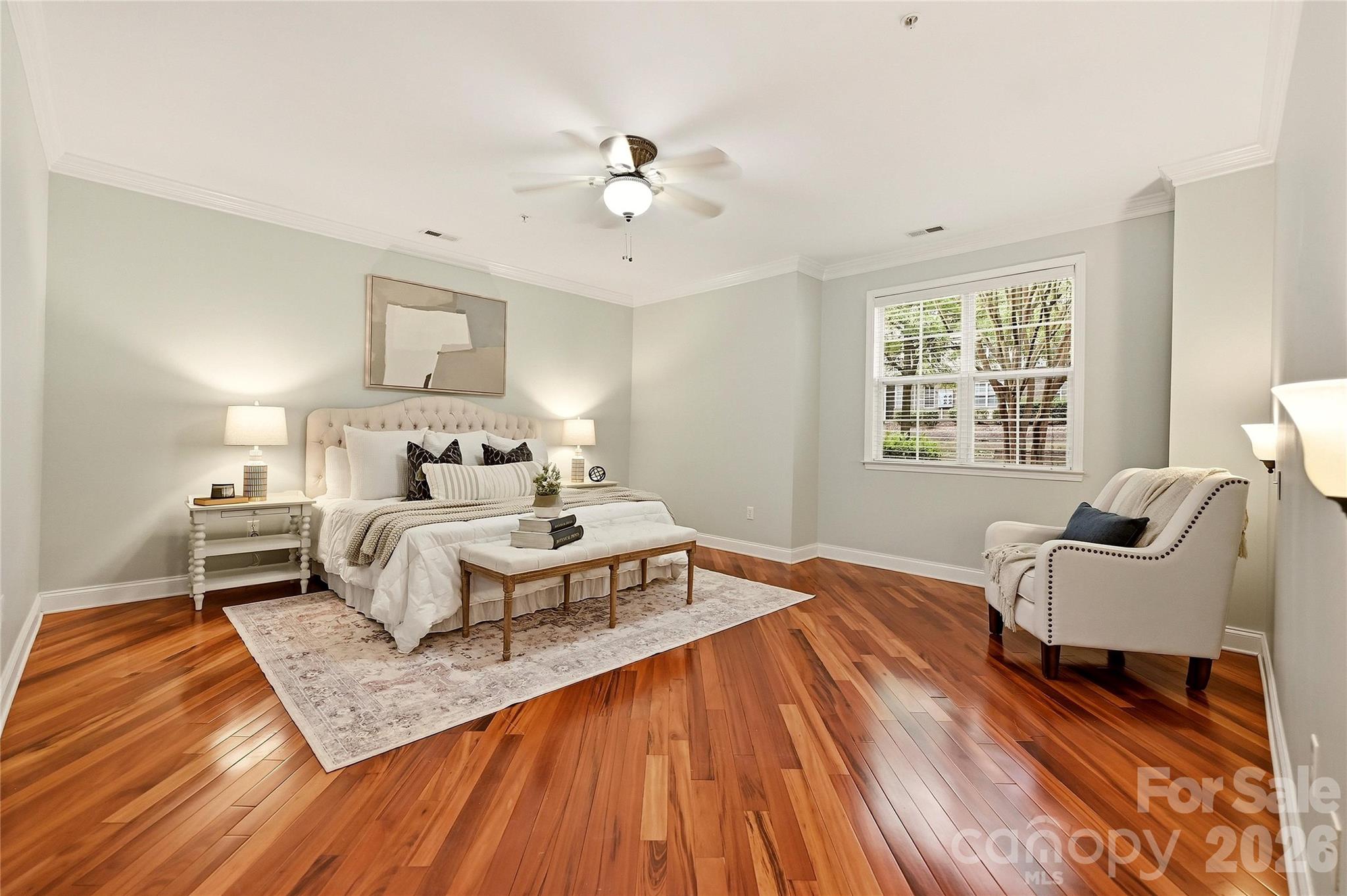 Spacious primary bedroom offers hardwood floors, a ceiling fan, and plenty of room for a complete bedroom suite. - 9009 Rosalyn Glen Road, Cornelius