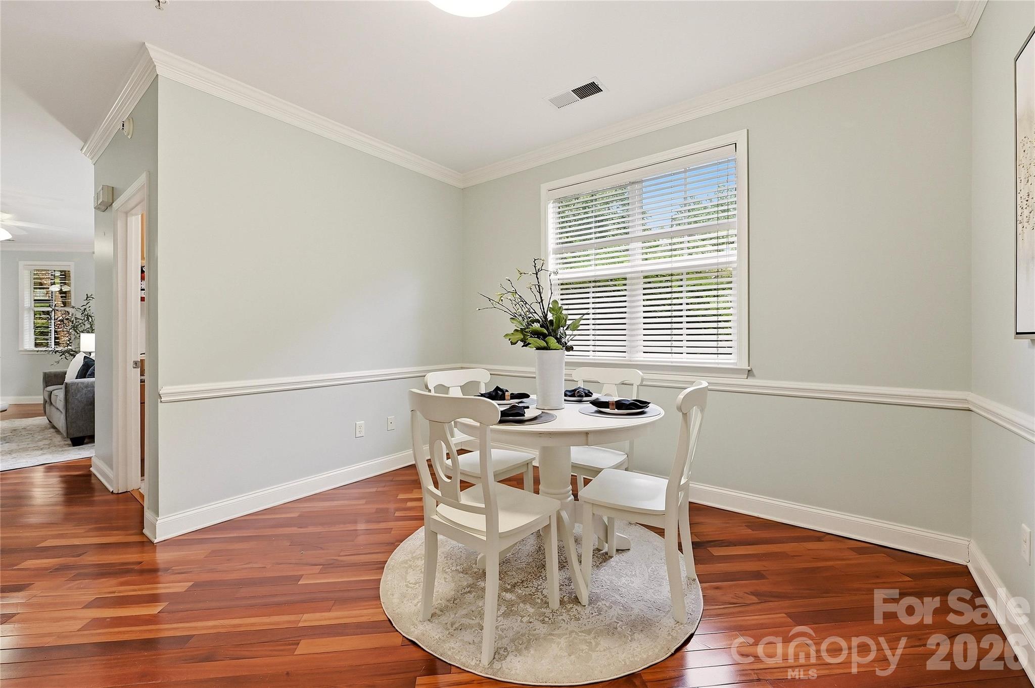 Bright dining area offers a dedicated space for casual meals with hardwood floors and classic chair-rail detailing. - 9009 Rosalyn Glen Road, Cornelius