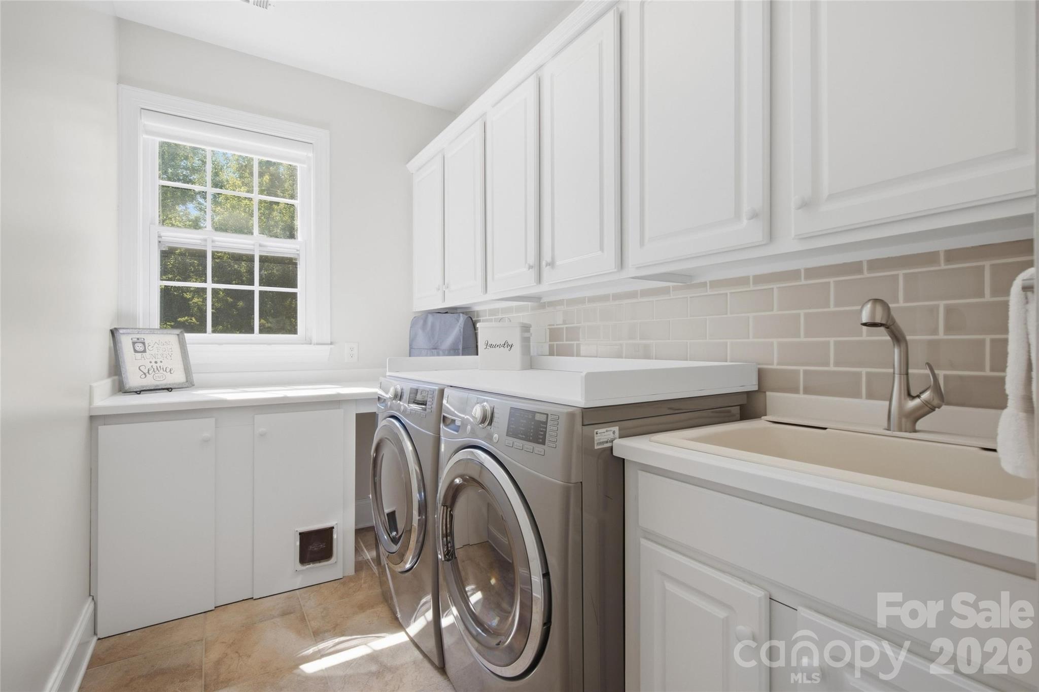 laundry on main floor with custom cabinetry! - 5134 Cressingham Drive, Indian Land