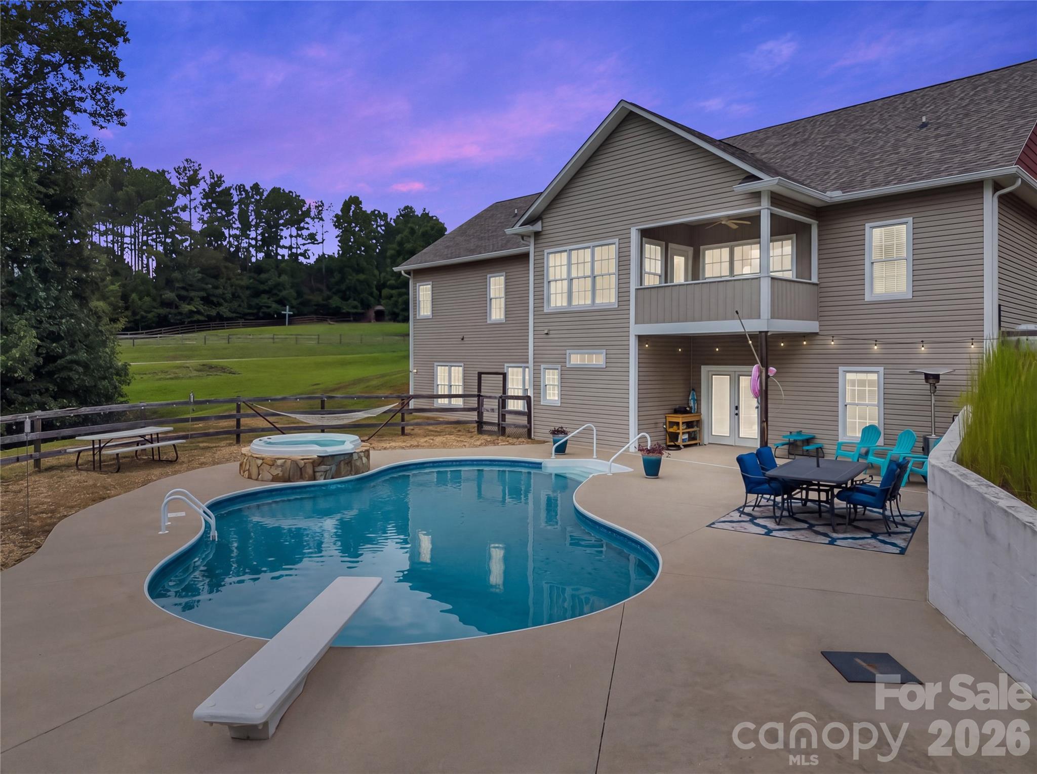 Imagine lovely evenings relaxing around the pool and patio area. This large, heated, in-ground saltwater pool offers the perfect place to relax, entertain, and enjoy unforgettable days with family and friends. The built-in waterfall spa adds an extra touch of luxury, creating a peaceful setting for unwinding after a long day. Whether you’re enjoying a refreshing swim, soaking in the spa, or gathering around the pool with friends, this exceptional outdoor space brings resort-style living right to your own backyard. - 27 & 56 Troy Lane, Tryon