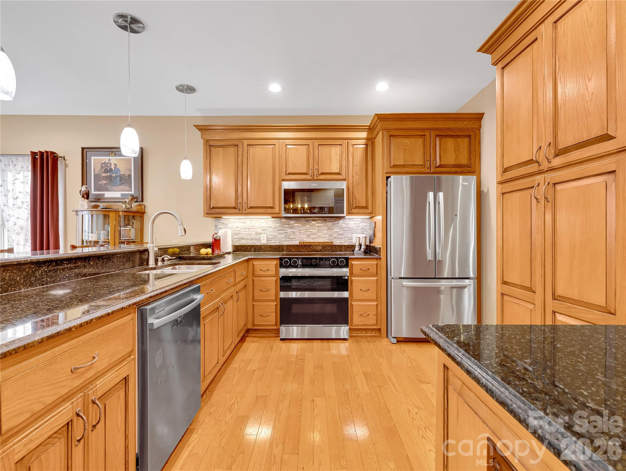 Pristine kitchen with tons of storage, granite countertops, range with double ovens and high quality appliances. All of the cabinetry in this home was custom built, including the bathroom cabinets, the built-ins in the laundry room and even the garage has custom cabinets! - 27 & 56 Troy Lane, Tryon
