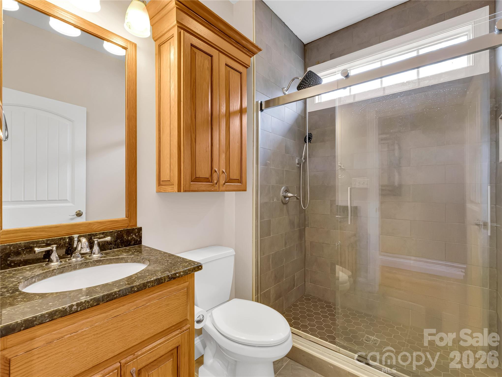 This full bath with a large tiled shower is located on the main floor. There is also a convenient half bath for guests on this level. - 27 & 56 Troy Lane, Tryon
