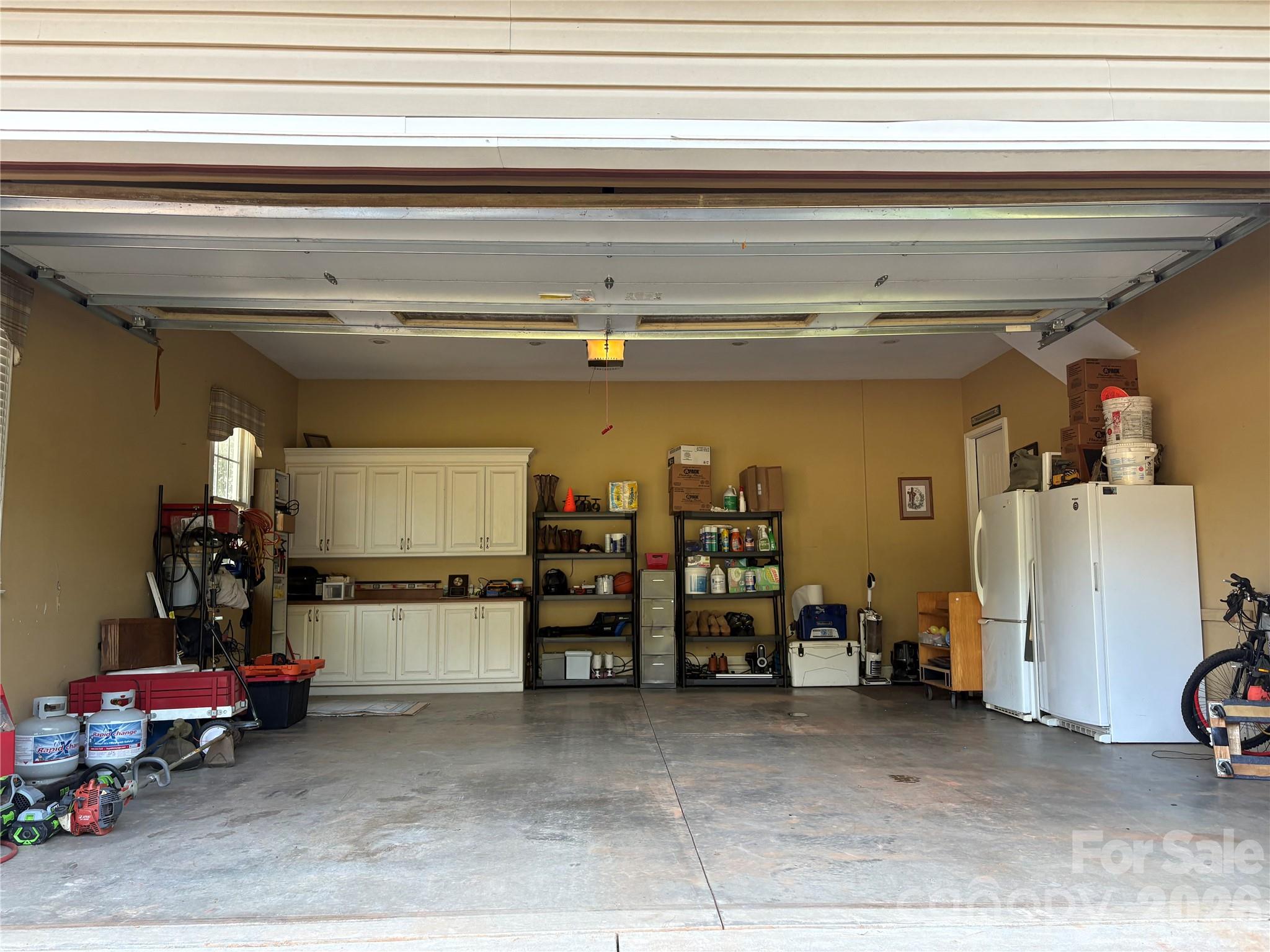Two car garage with built in cabinets and real staircase up to an unfinished storage space above. - 27 & 56 Troy Lane, Tryon