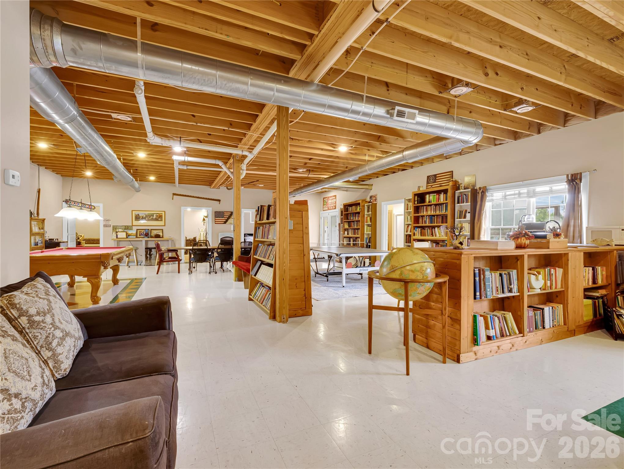 Enormous finished basement space was designed to look like a modern brew pub with industrial style finishes. Ping pong table, pool table, lounge area, bedroom, full bath and even a weight room can be found in this space! Double doors open out to the pool and patio area. - 27 & 56 Troy Lane, Tryon