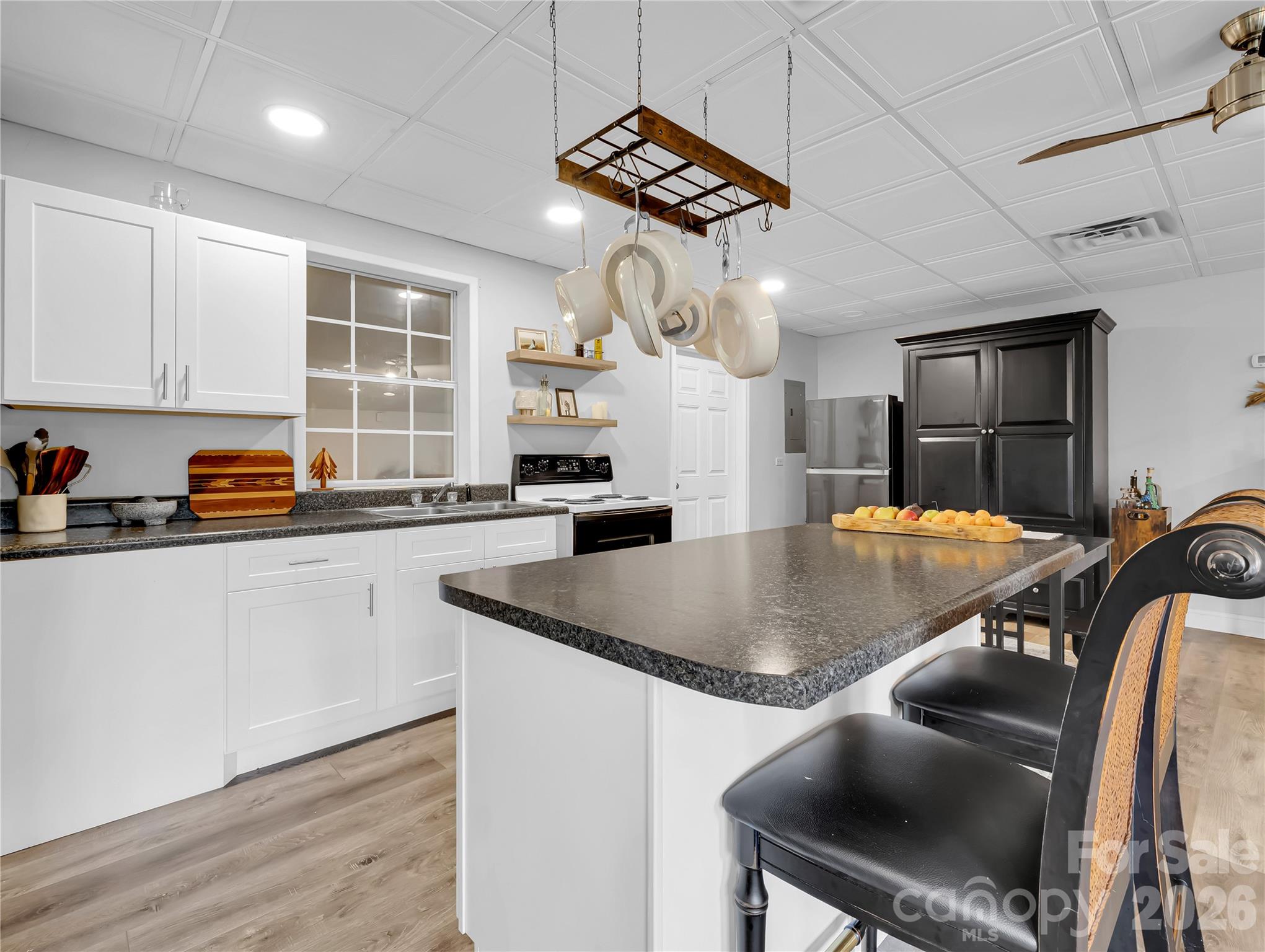Light bright full kitchen has an island with storage and a breakfast bar. - 27 & 56 Troy Lane, Tryon