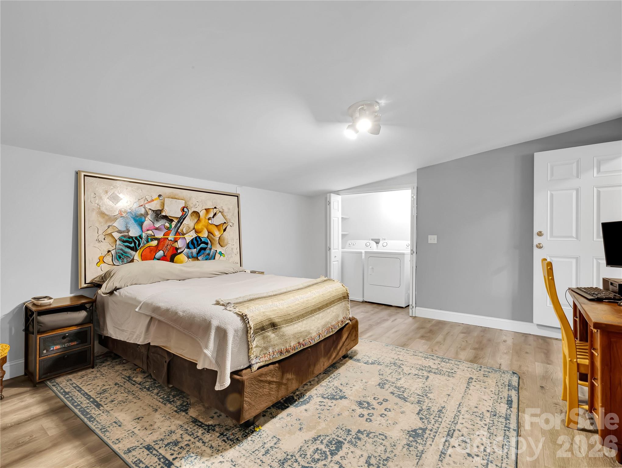 Bedroom in the guest house with a washer and dryer space and a large walk in closet. Vinyl plank floors. - 27 & 56 Troy Lane, Tryon