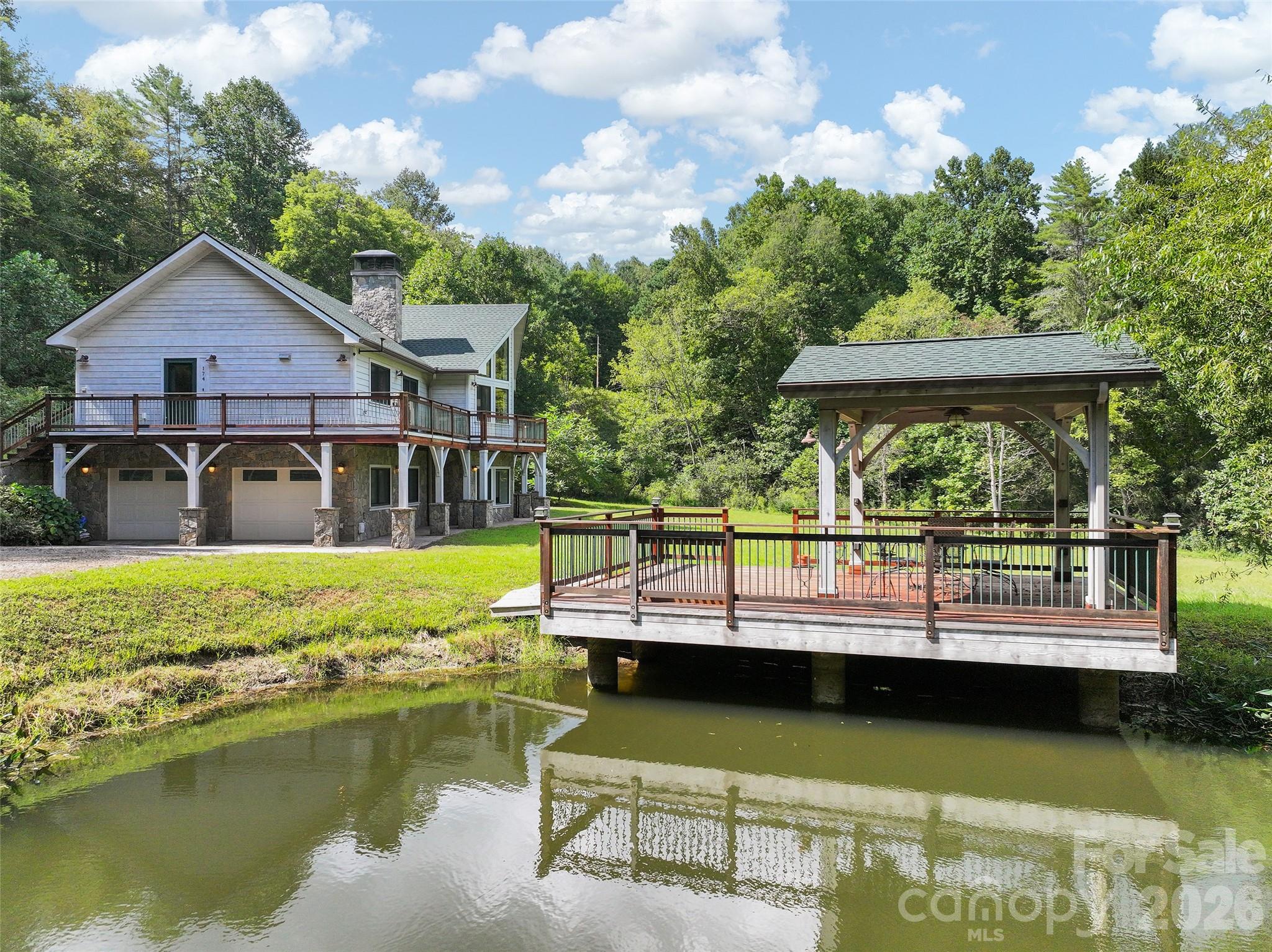 Private pond with covered dock featuring durable ironwood decking and railing. - 174b Marina Cove, Waynesville