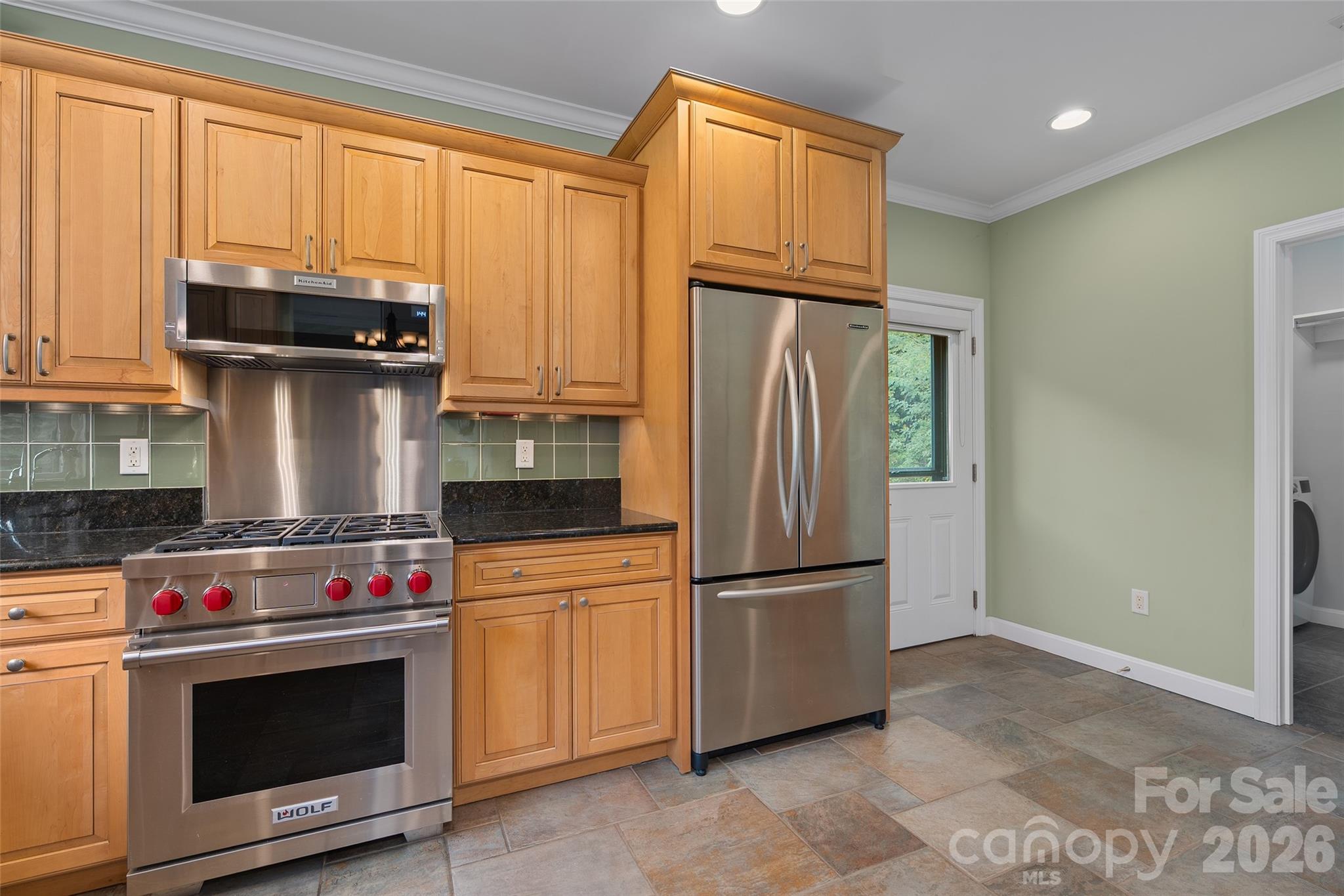 Updated kitchen appliances complement the home's warm cabinetry and functional design. - 174b Marina Cove, Waynesville