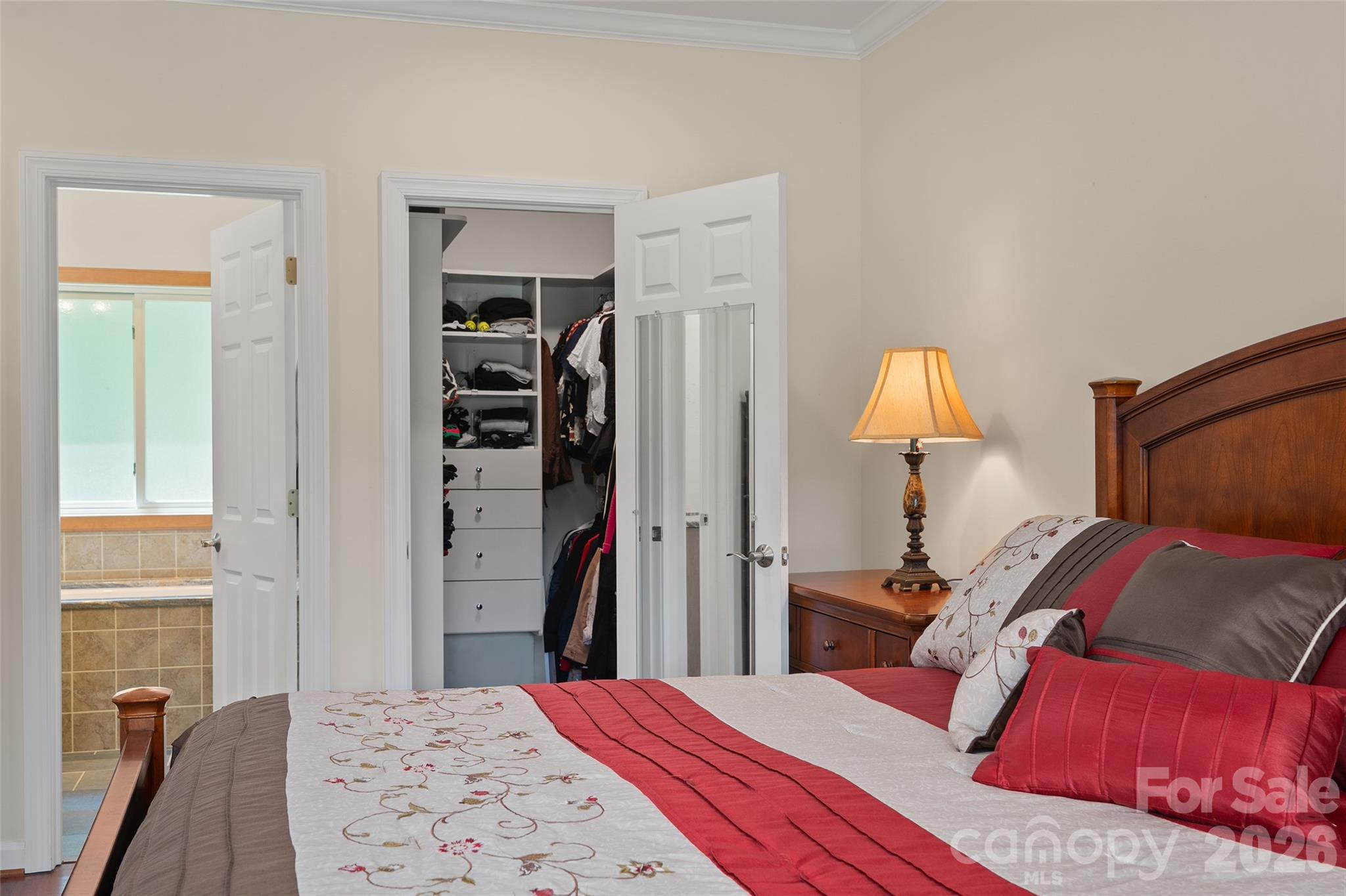 Spacious primary suite with a large walk-in closet with custom shelving. - 174b Marina Cove, Waynesville