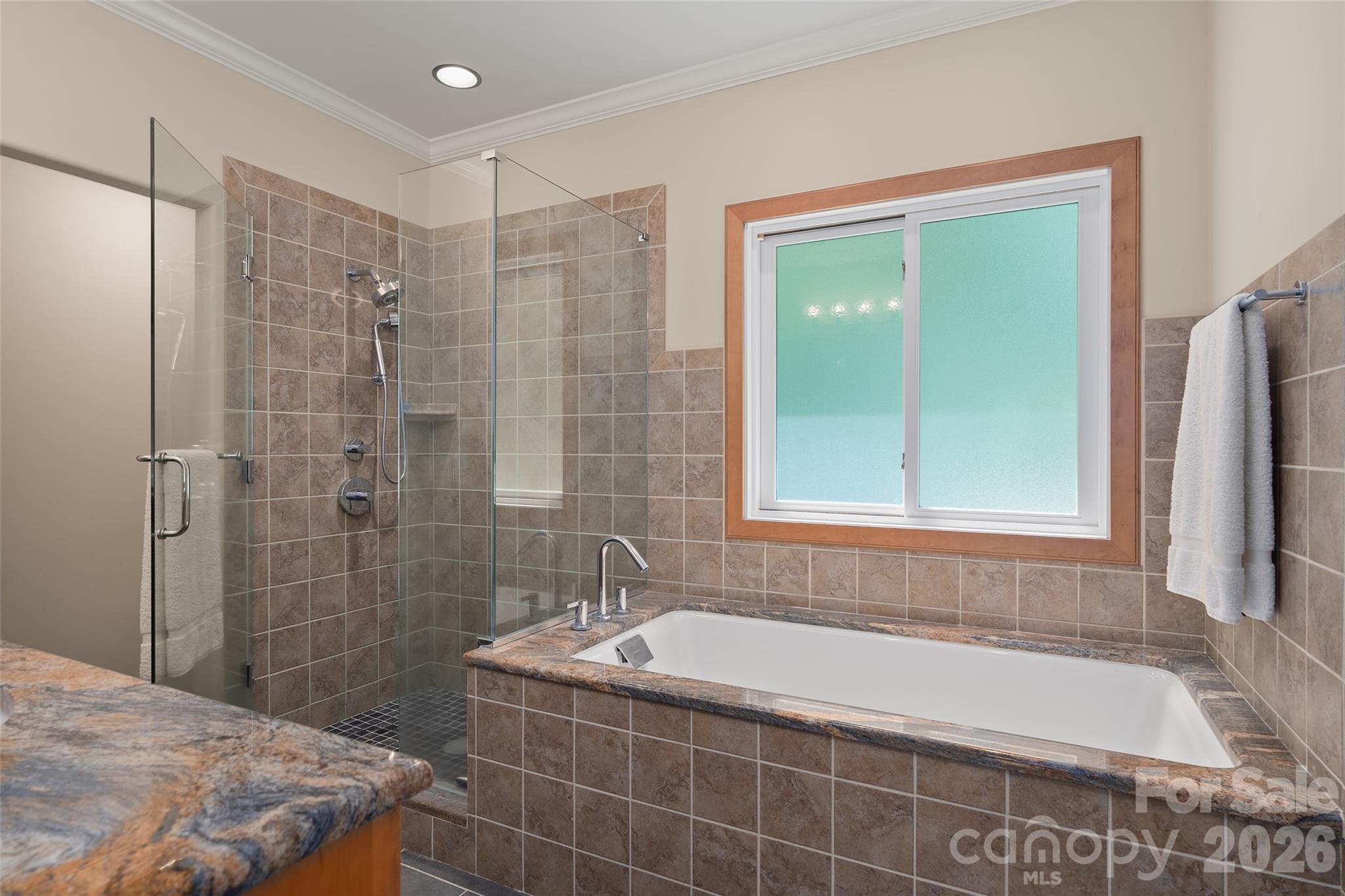 Large garden tub and beautifully tiled shower create a relaxing primary bath retreat. - 174b Marina Cove, Waynesville