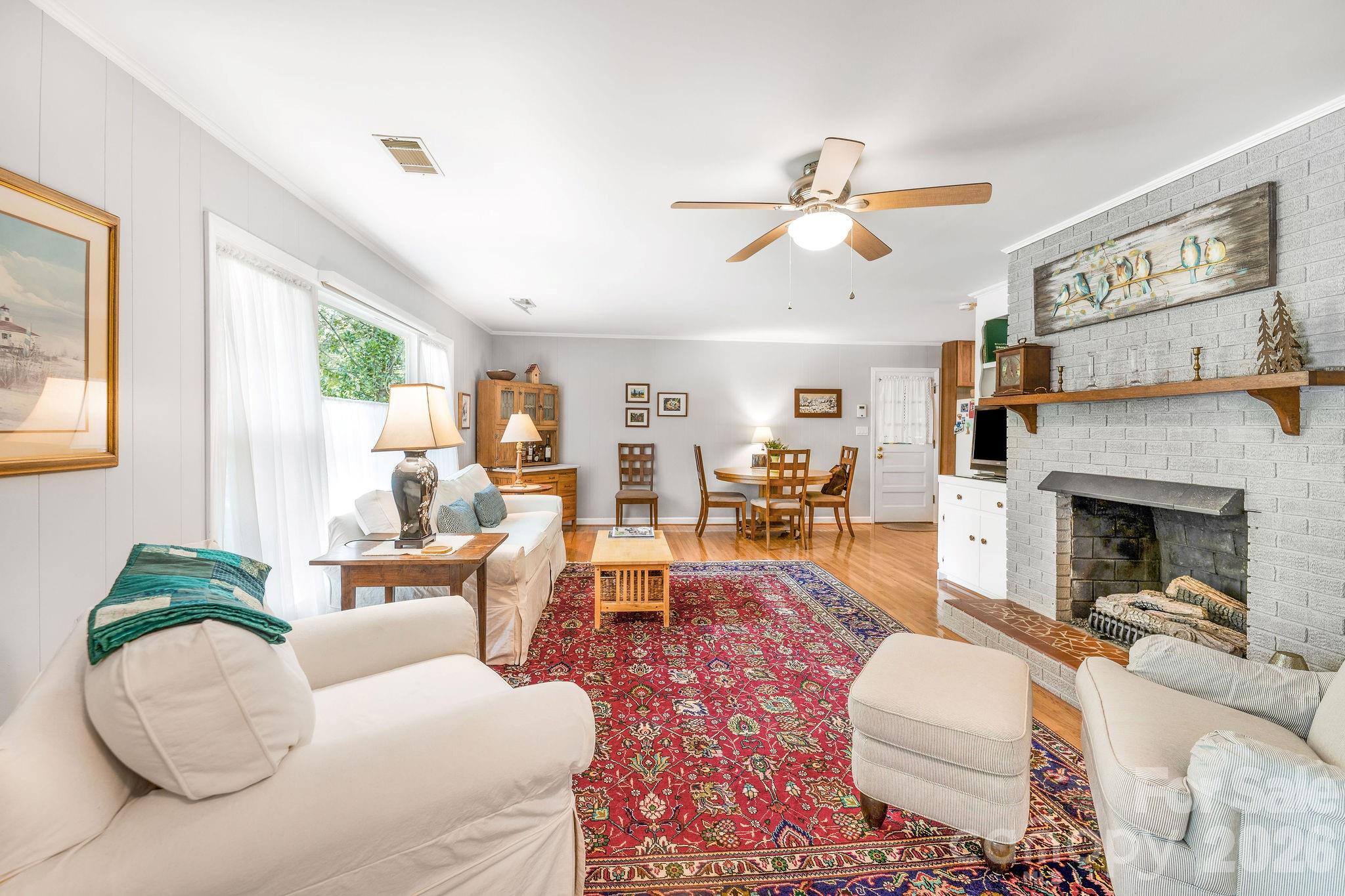 Large living room with picture window and lots of natural light and a gas fireplace greet you as you walk inside. - 1 Pheasant Ridge Drive, Asheville
