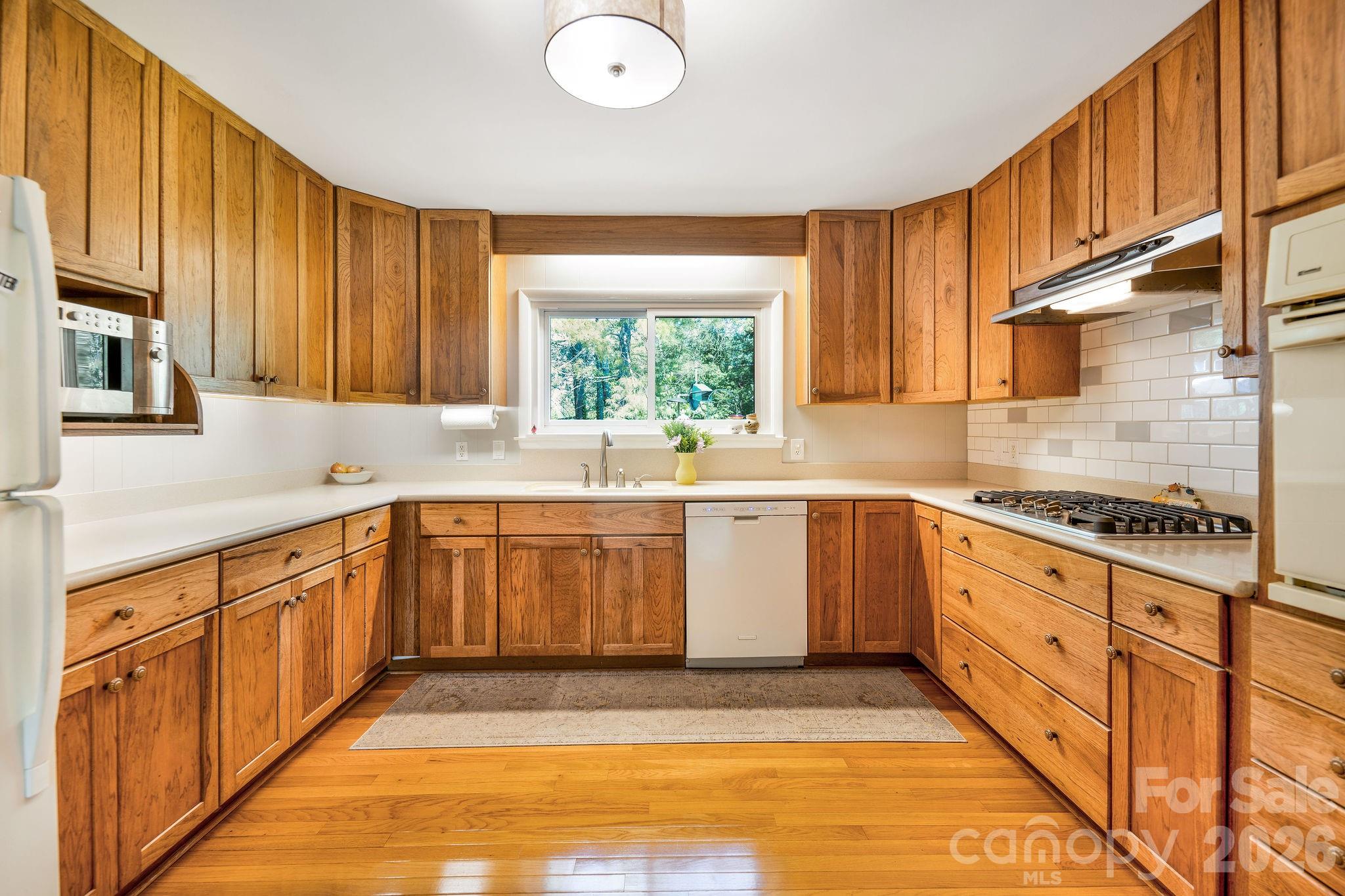 Open floor plan leads into Kitchen with lots of storage and pretty wood cabinets. - 1 Pheasant Ridge Drive, Asheville