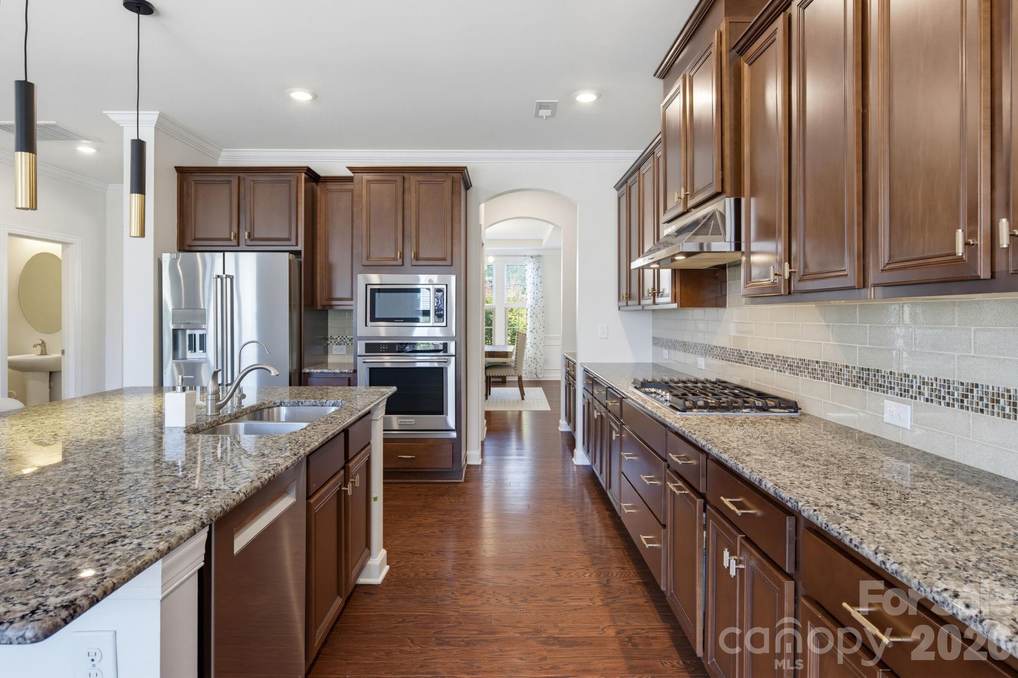 The kitchen offers abundant cabinetry, granite work surfaces, and stainless appliances, with a layout designed for comfortable everyday cooking - 8315 Breton Way, Harrisburg