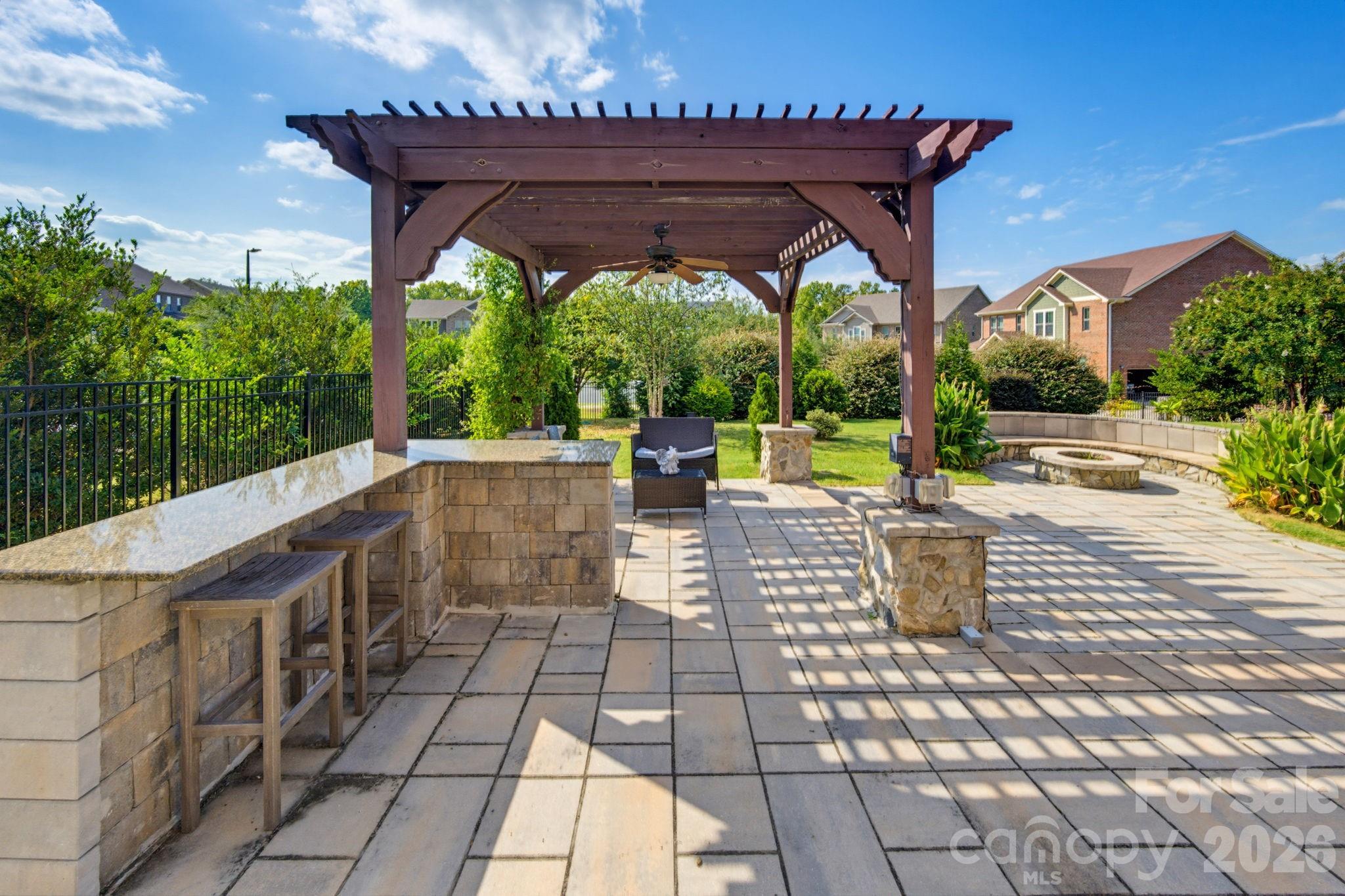 The pergola and outdoor kitchen area set the stage for shaded afternoons, casual dinners, and relaxed evenings outside. - 8315 Breton Way, Harrisburg