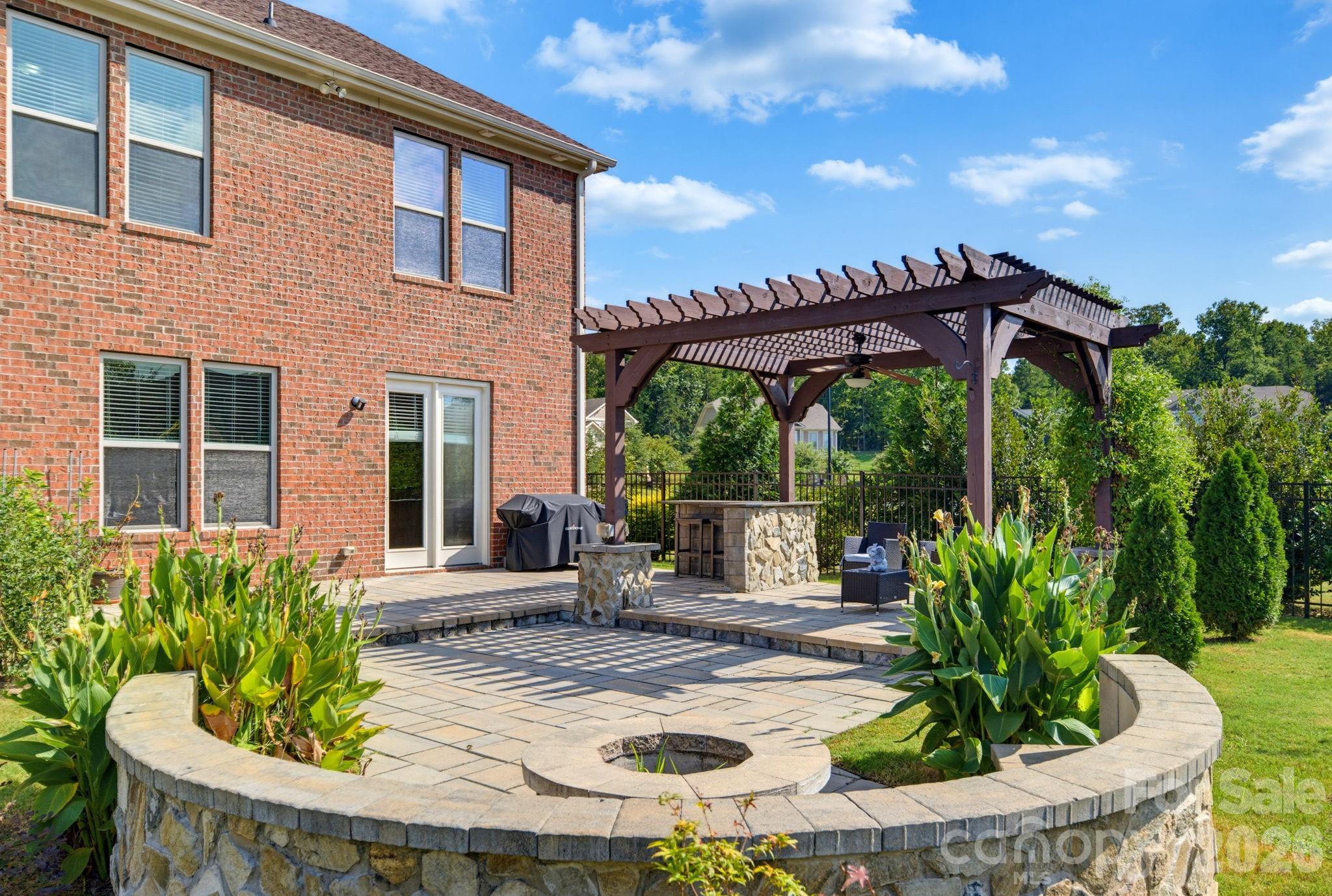 The curved fire pit surround adds a natural gathering place for cool evenings, conversation, and roasted marshmallows under the stars. - 8315 Breton Way, Harrisburg