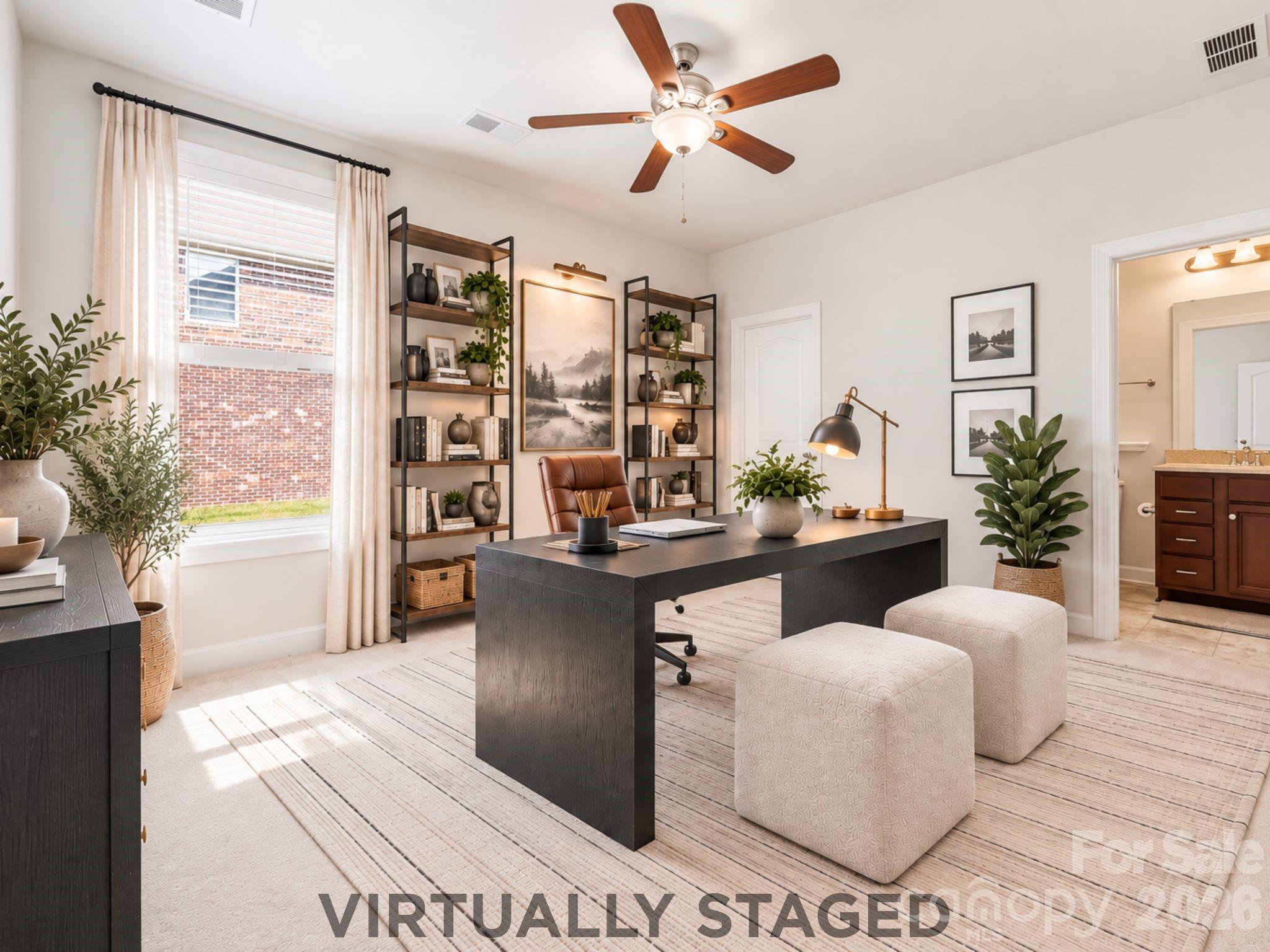 A Sophisticated Work-From-Home Space | Virtually Staged — Or reimagine the same room as an impressive private home office, with ample space for a substantial desk, library-style shelving, and additional seating. Its first-floor location creates separation between work and the home's primary living spaces, while the nearby full bath preserves the flexibility to convert the room back to guest accommodations whenever needed. - 8315 Breton Way, Harrisburg