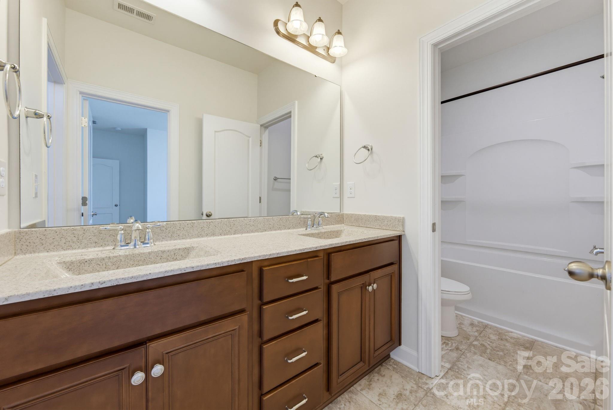 The shared bath provides a double-sink vanity and convenient access between the secondary bedrooms. - 8315 Breton Way, Harrisburg