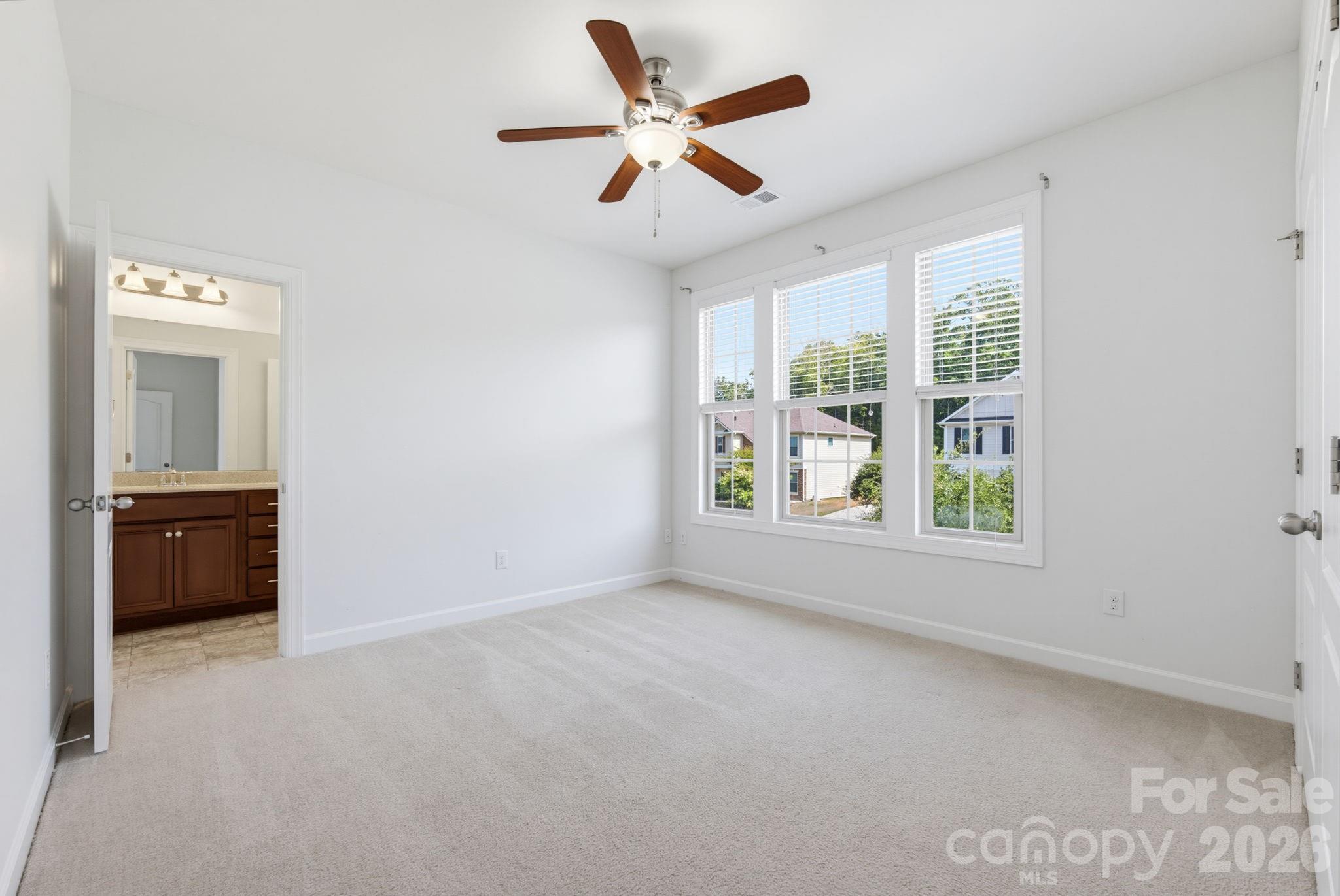 The unstaged view reveals the room’s generous, flexible footprint, three light-filled windows and convenient bathroom access—ready to become an additional bedroom or welcoming guest space. - 8315 Breton Way, Harrisburg