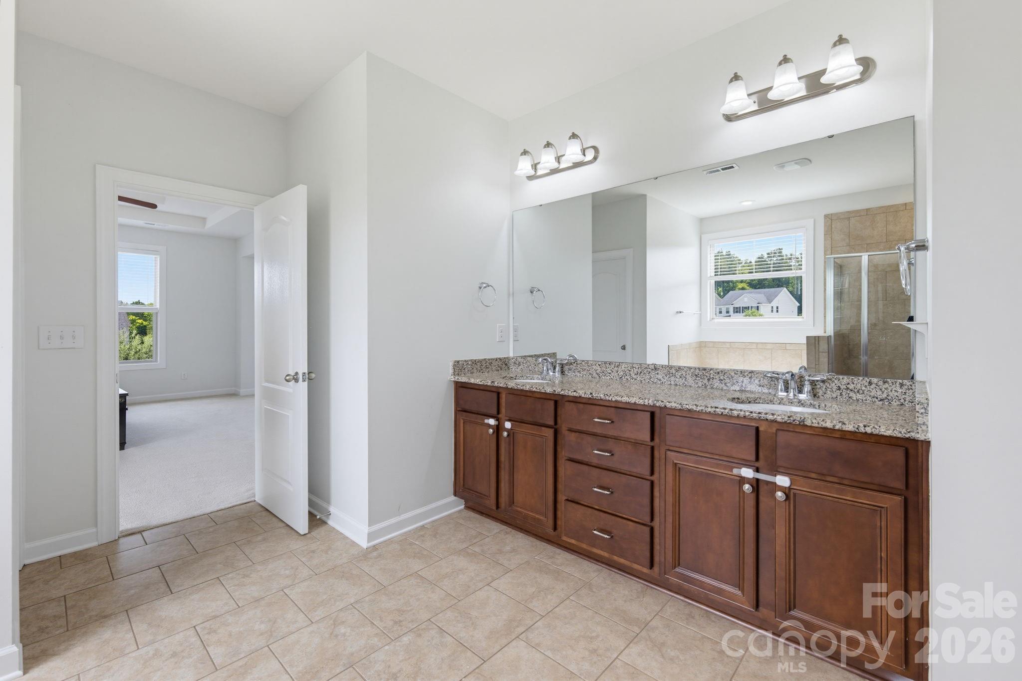 Double sinks and generous cabinetry make the primary bath comfortable for shared morning routines. - 8315 Breton Way, Harrisburg