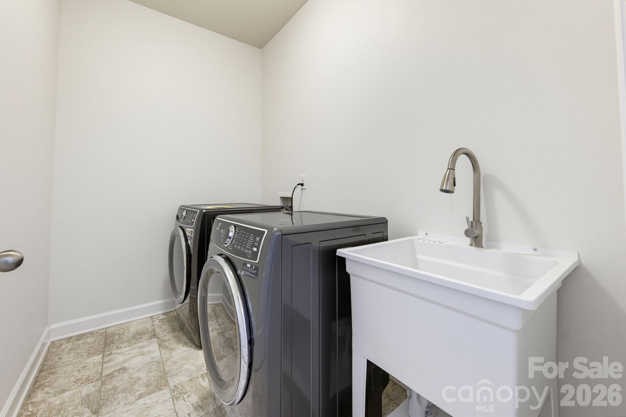 The upstairs laundry room includes a utility sink and space to make household routines more manageable. - 8315 Breton Way, Harrisburg