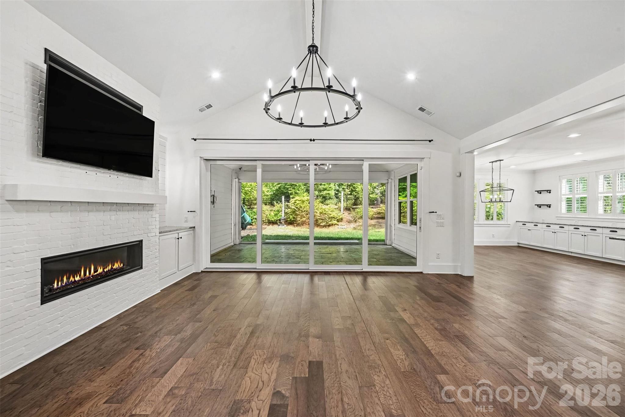 Painted brick fireplace with Linear fireplace, built ins on either side of the fireplace with shiplap accents sconces TV over fireplace remains - 3142 Sherman Drive, Lancaster