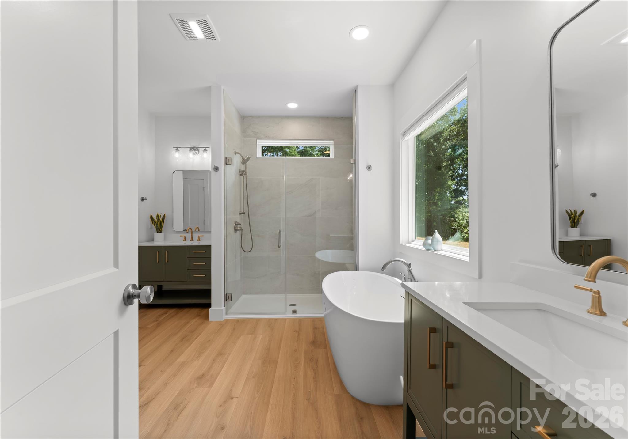 A glass-enclosed shower with a handheld showerhead adds comfort and convenience to the adjoining bath. - 143 Hideaway Lane, Mooresville