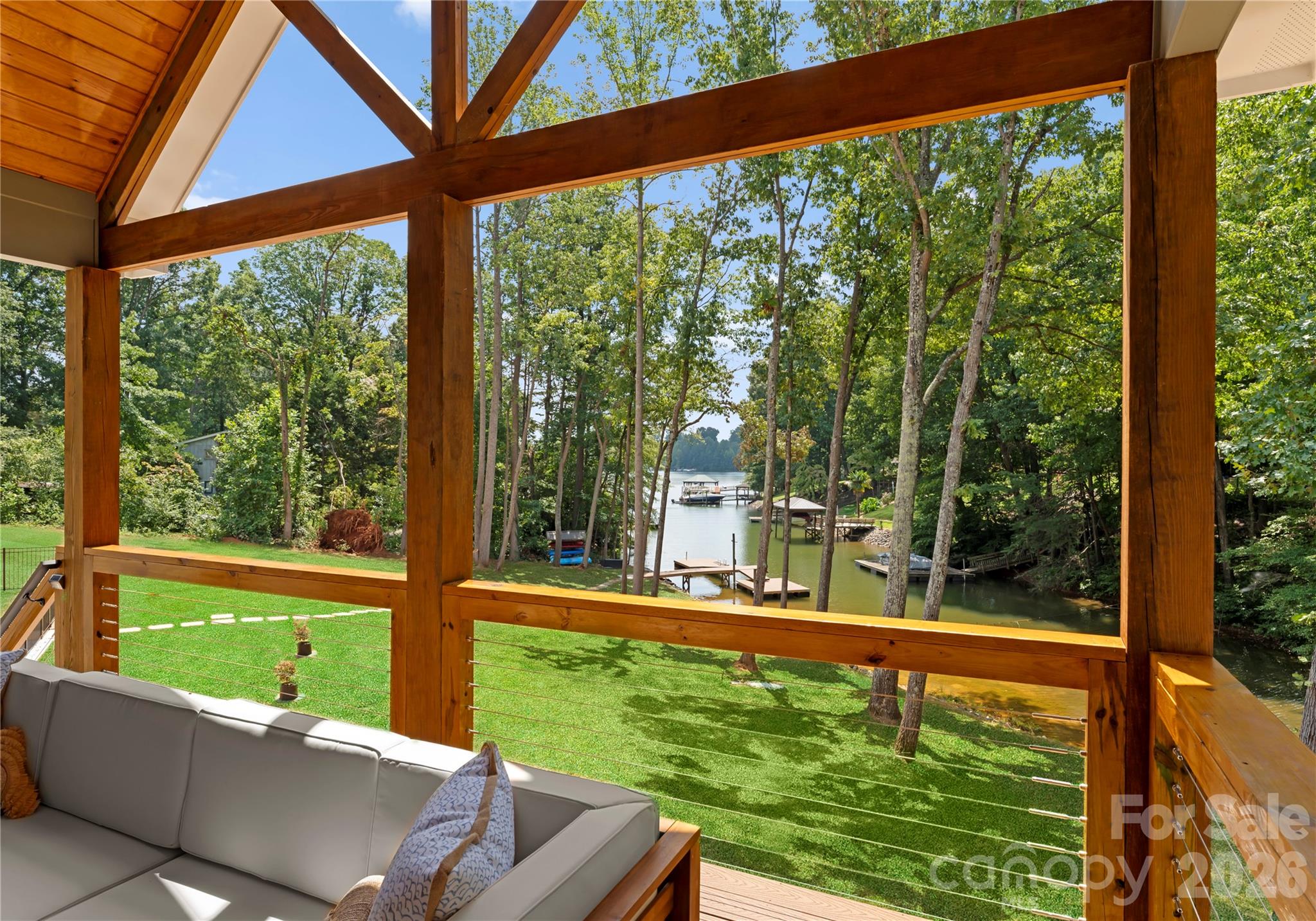 Timber framing draws the eye across the lawn to the dock and quiet cove—a beautiful backdrop for relaxing on the covered porch. - 143 Hideaway Lane, Mooresville