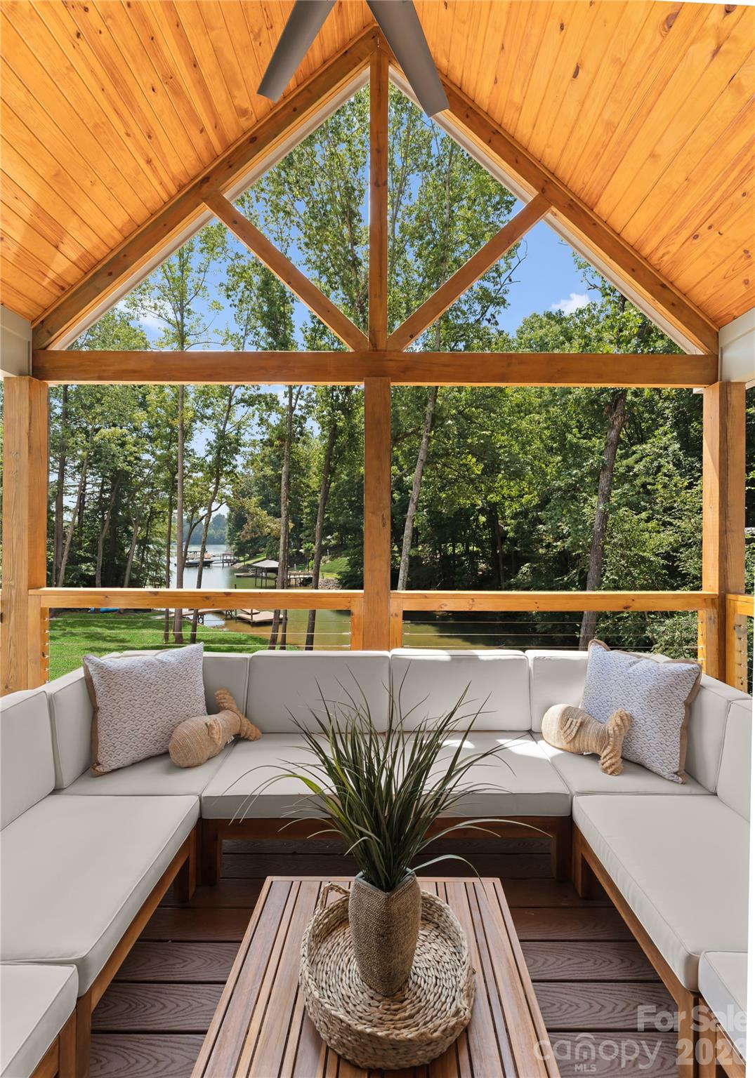 Settle in beneath the vaulted porch ceiling and enjoy a view through the trees to the dock and water. - 143 Hideaway Lane, Mooresville
