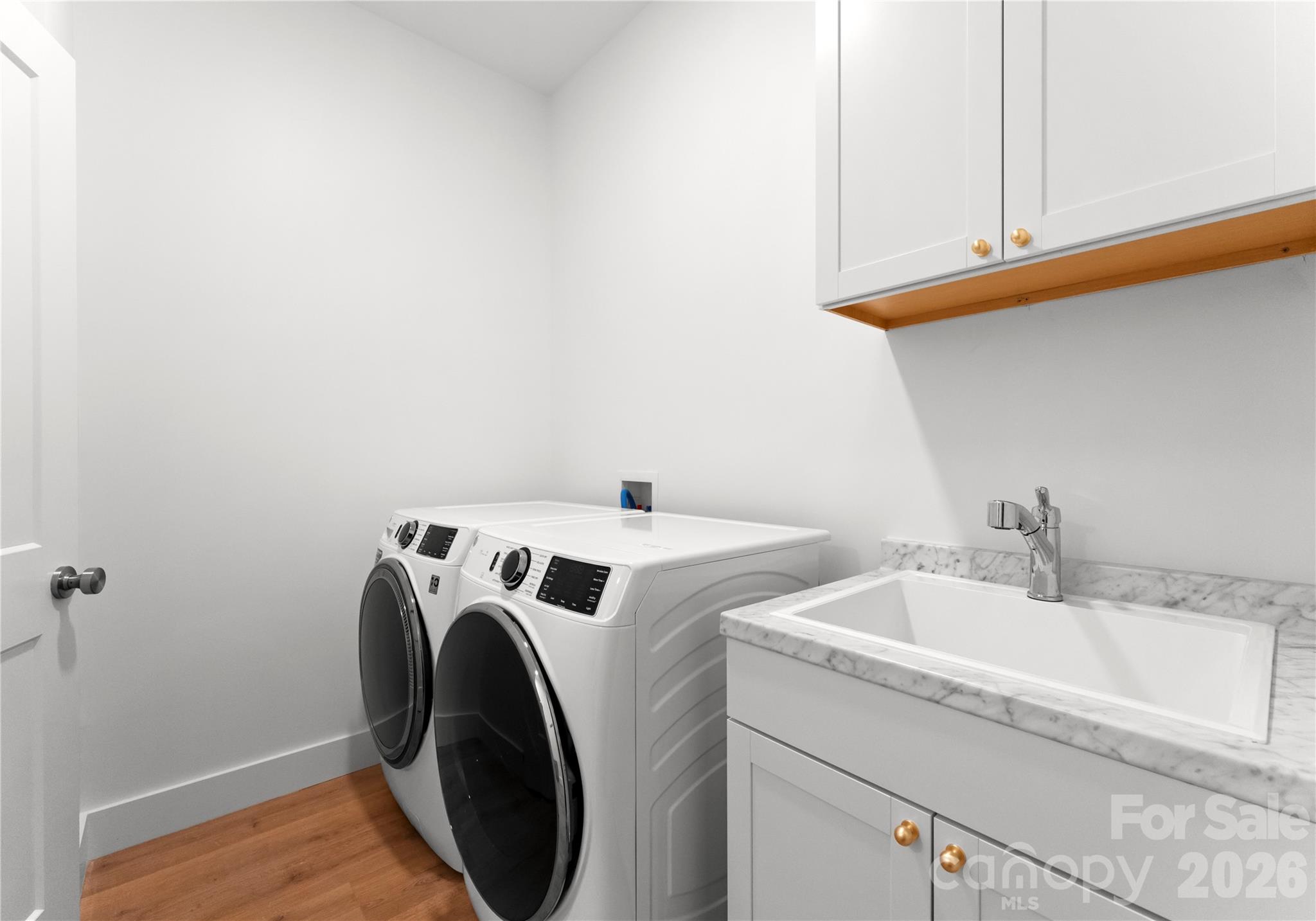 The second, downstairs laundry area with a utility sink and overhead cabinets makes everyday living and guest turnovers more convenient. - 143 Hideaway Lane, Mooresville