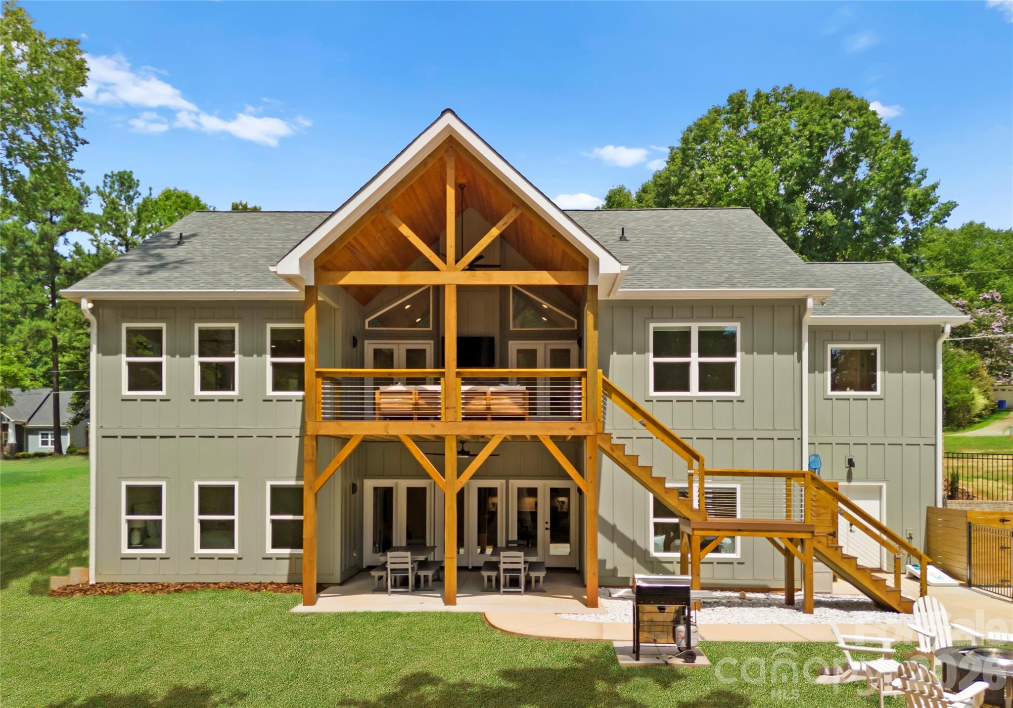 A striking timber-framed porch anchors the rear of the home, providing covered outdoor space on both levels. - 143 Hideaway Lane, Mooresville