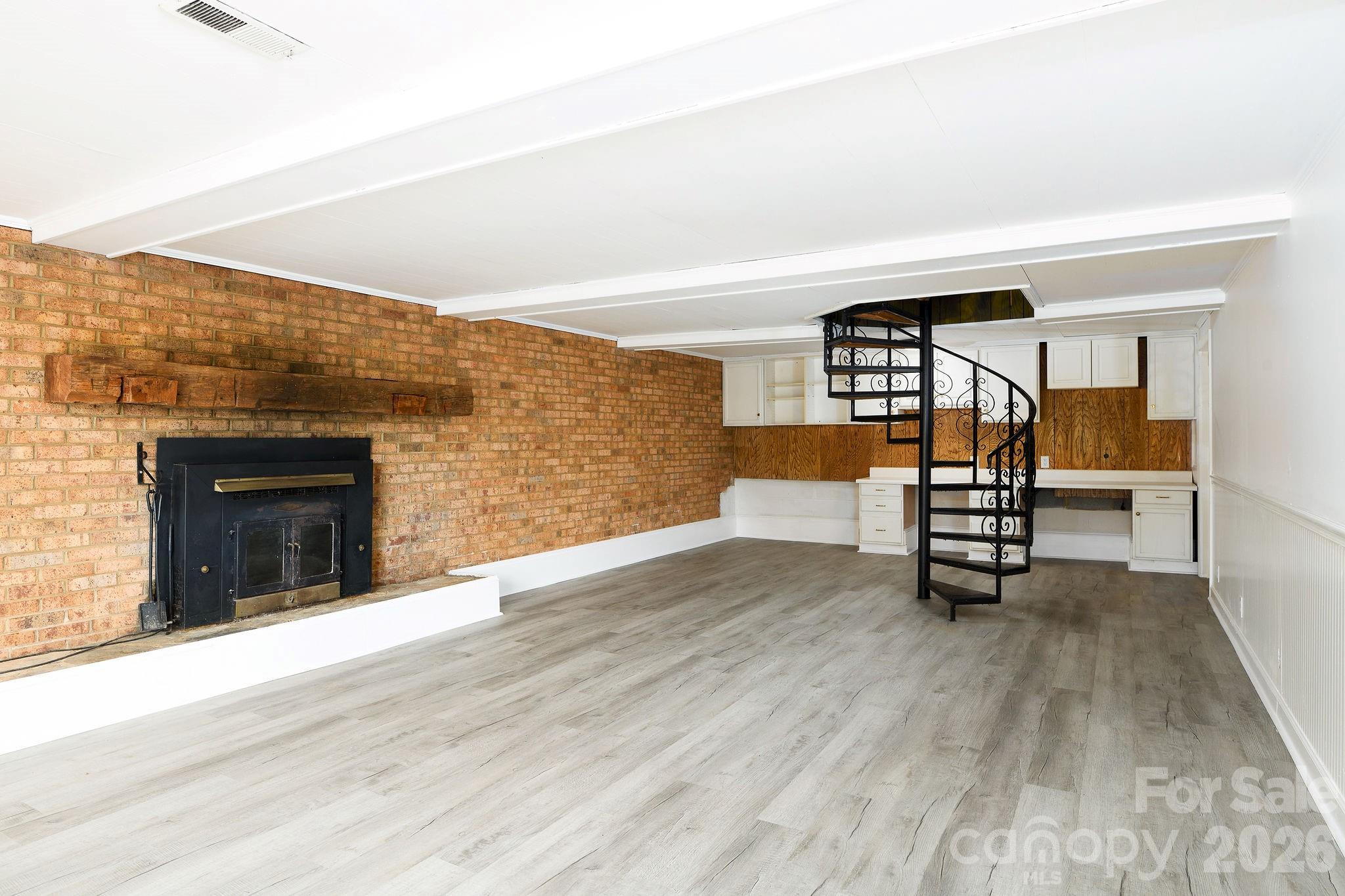 Use the spiral staircase to enter the finished area of basement with new LVP flooring and fresh paint! - 3910 Fallston Road, Shelby