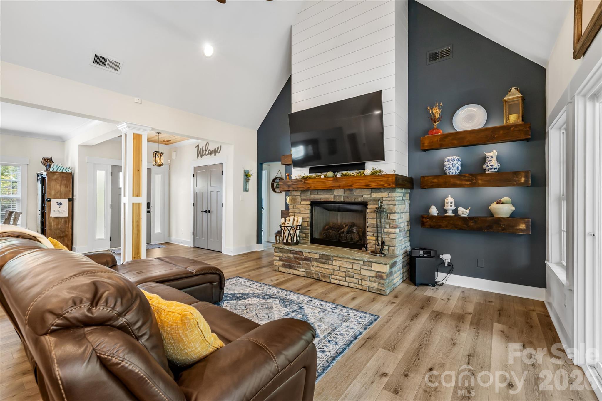 Soaring ceilings and a beautiful stone fireplace create a cozy focal point - 1604 Aragon Beach Road, Rock Hill