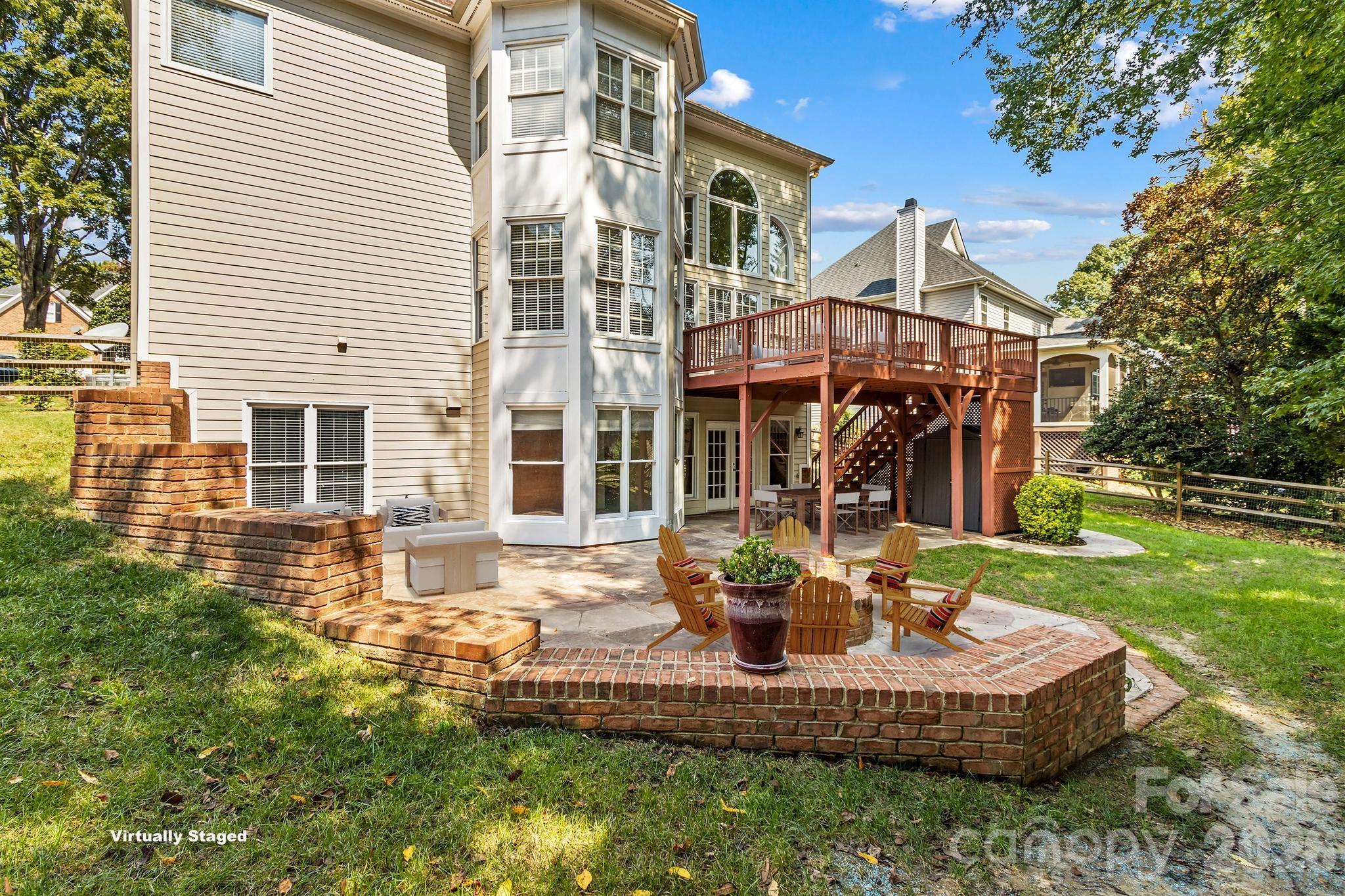 Virtually staged concrete patio with sitting area, fire pit area, and covered dining area. - 12822 Cadgwith Cove Drive, Huntersville