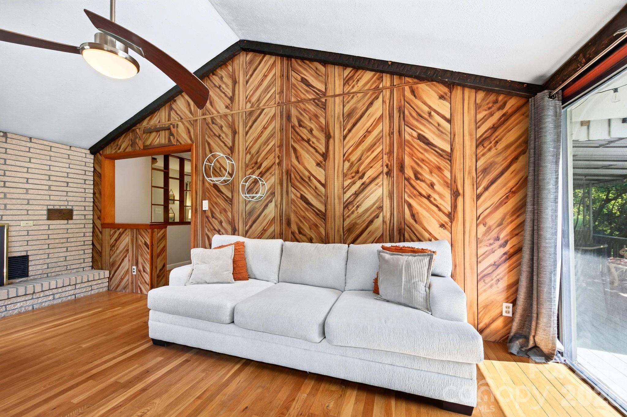 Family room with vaulted ceiling, distinctive wood paneling and woodstove - 109 Wilshire Drive, Asheville