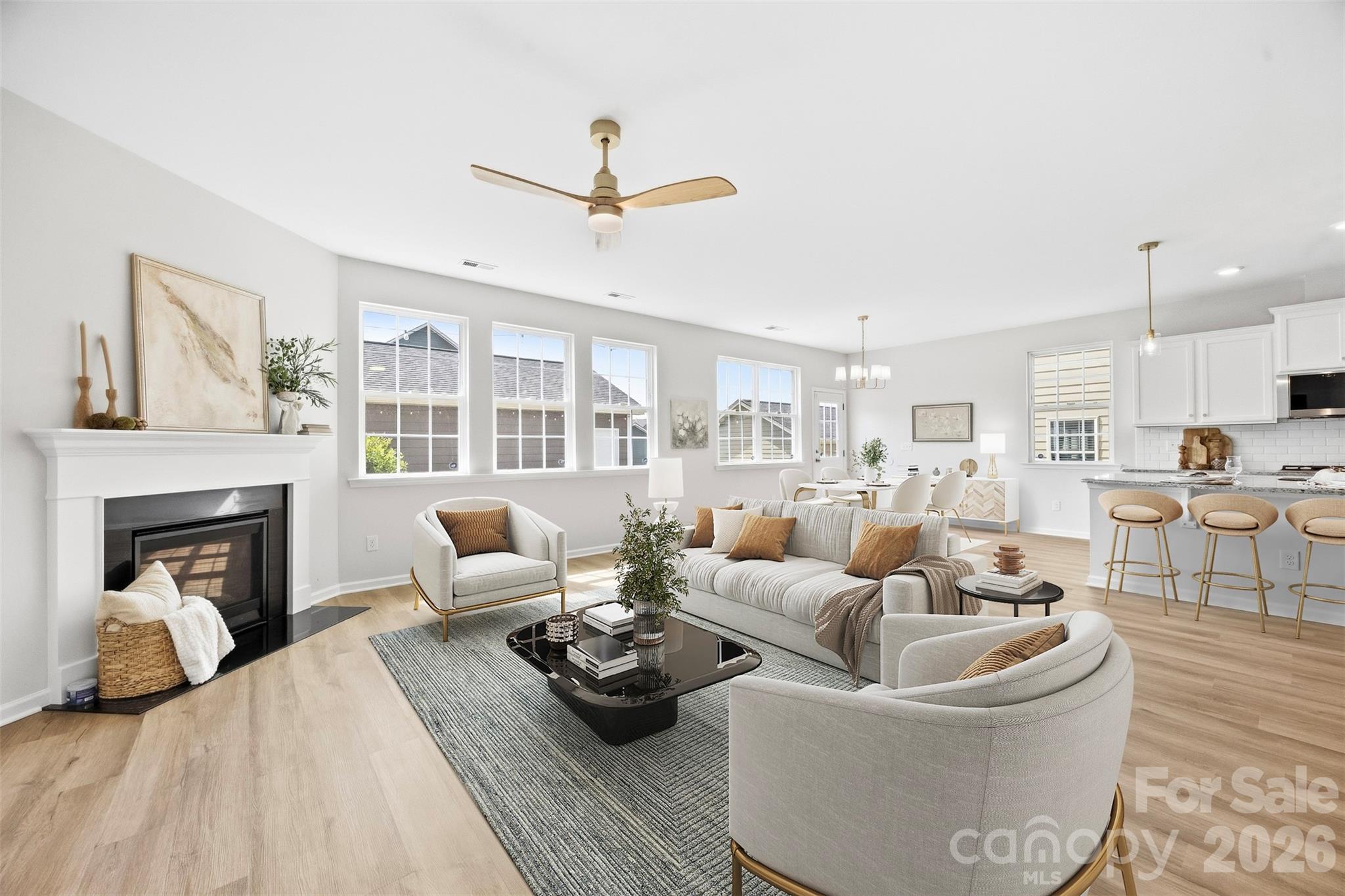 Bright, open-concept living space featuring a cozy fireplace and seamless flow into the kitchen and dining areas - 2015 Kensley Drive, Waxhaw