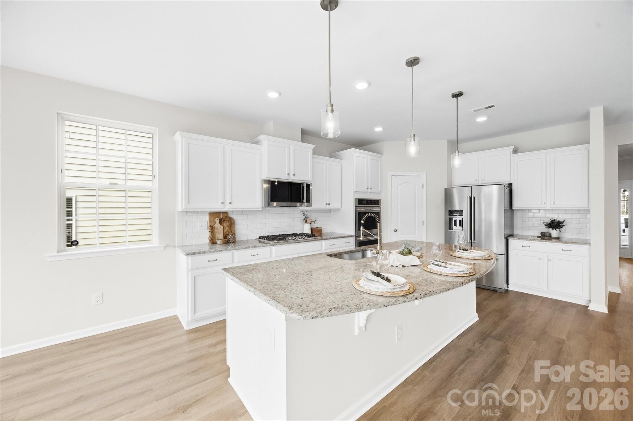 Oversized island provides ample prep space and casual seating for everyday living and entertaining - 2015 Kensley Drive, Waxhaw