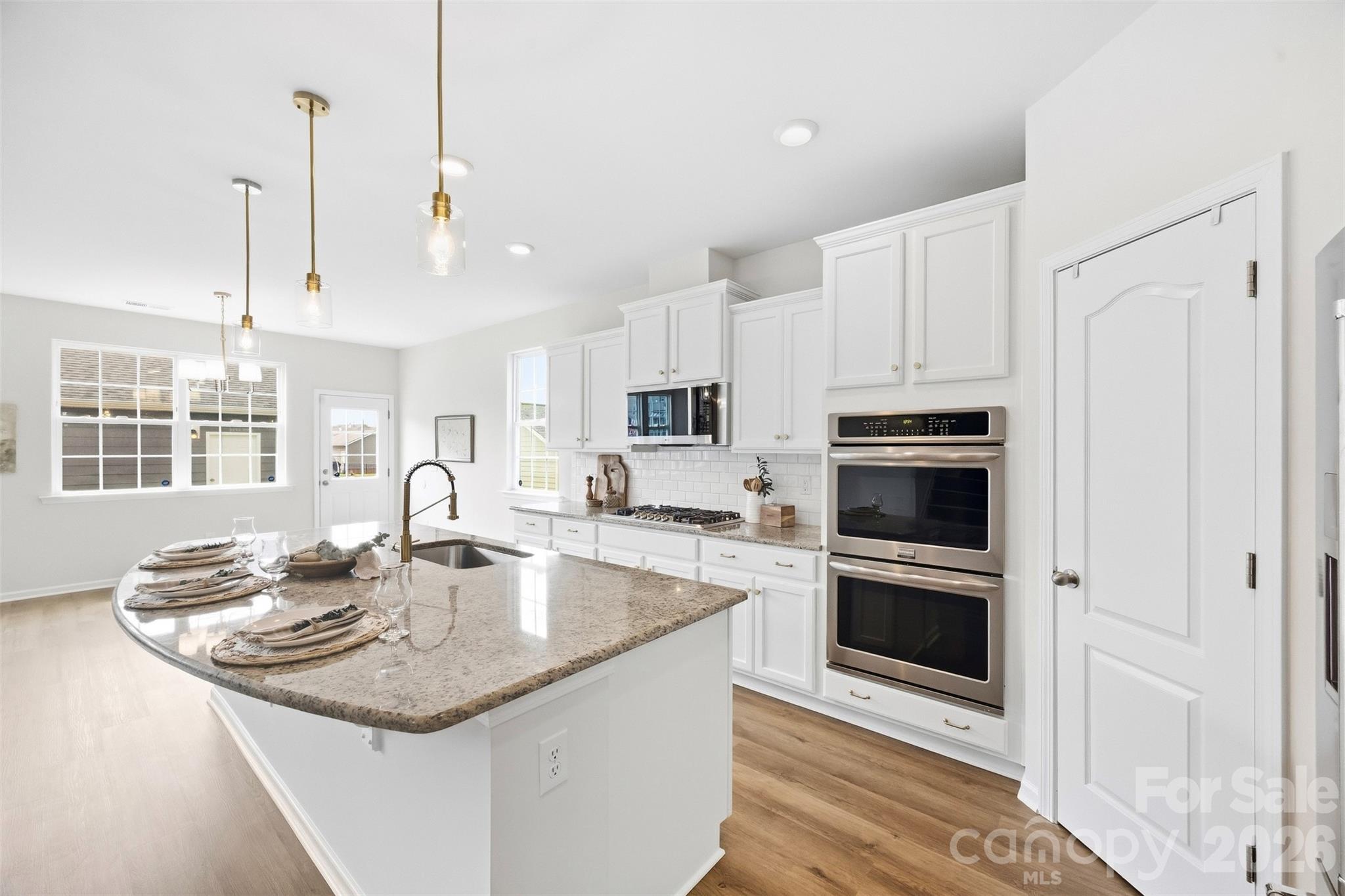 Fresh kitchen updates include new cabinet and drawer hardware, a new faucet, and stylish new pendant lighting - 2015 Kensley Drive, Waxhaw