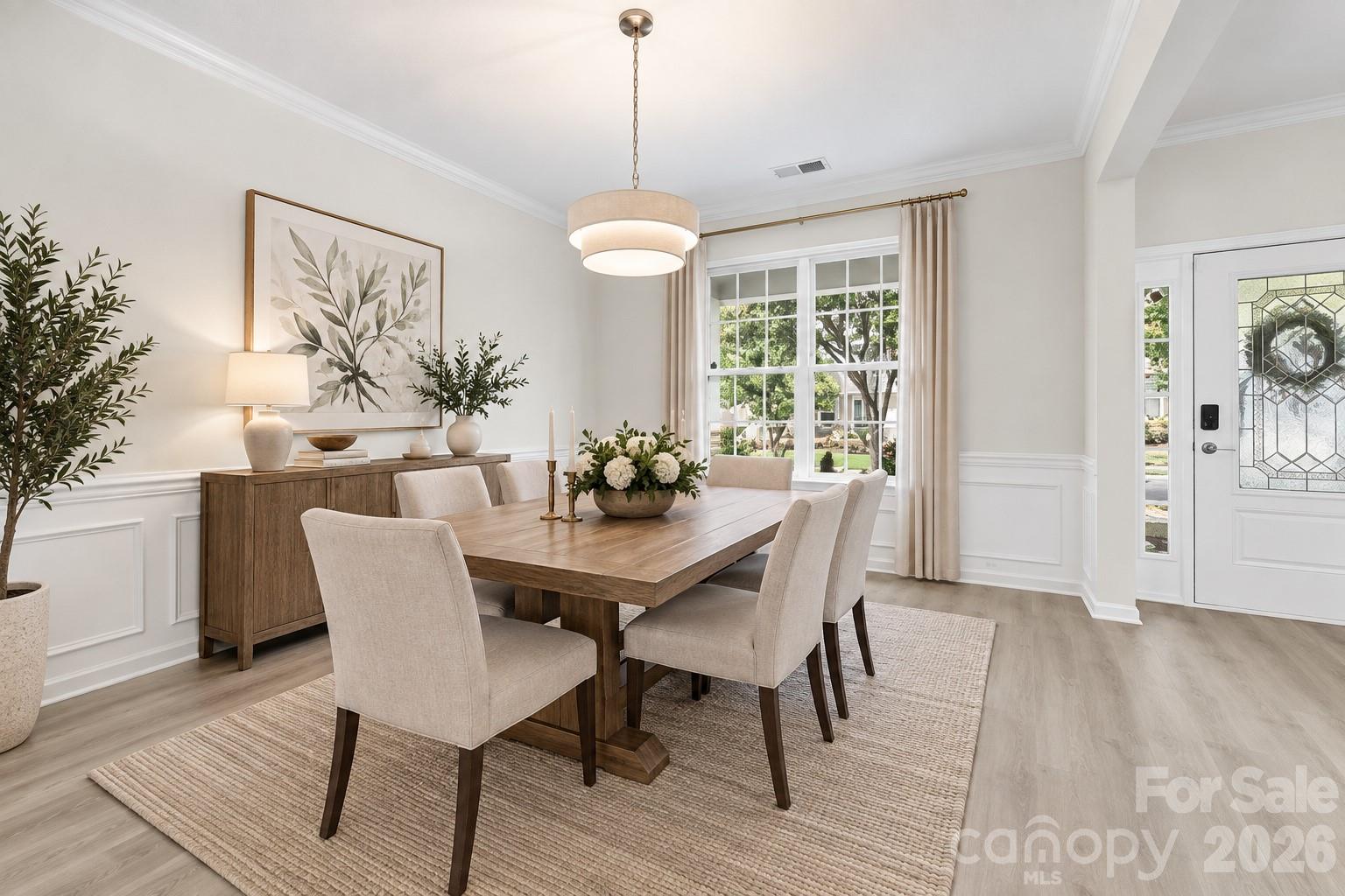Elegant formal dining room features classic wainscoting, crown molding, and a beautiful new light fixture - 2015 Kensley Drive, Waxhaw